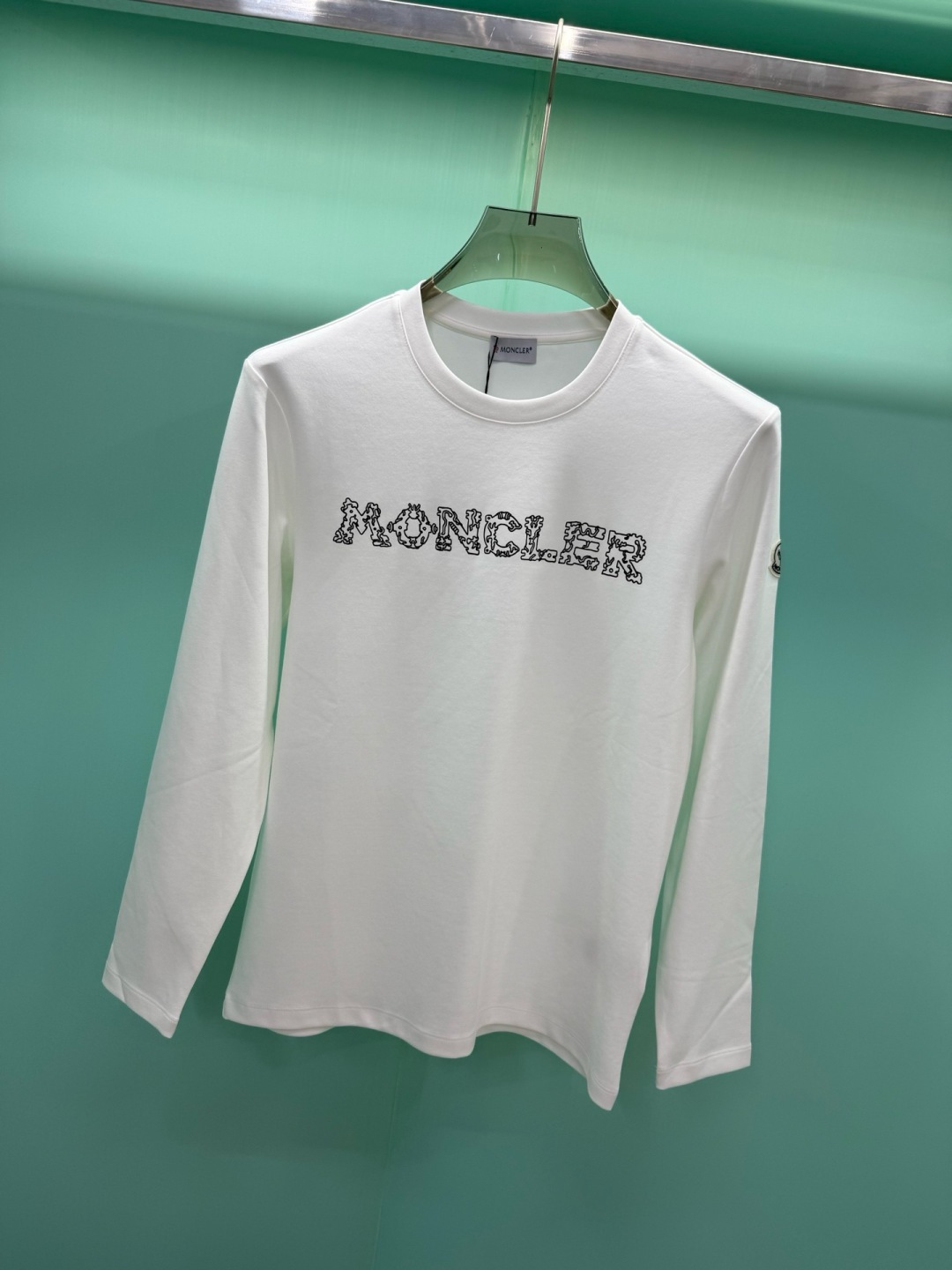 Moncler2026秋冬新品228克纯棉镂空印花工艺​​经典款字母长袖T恤，设计简约但细节感十足，适合追求低调质感的穿