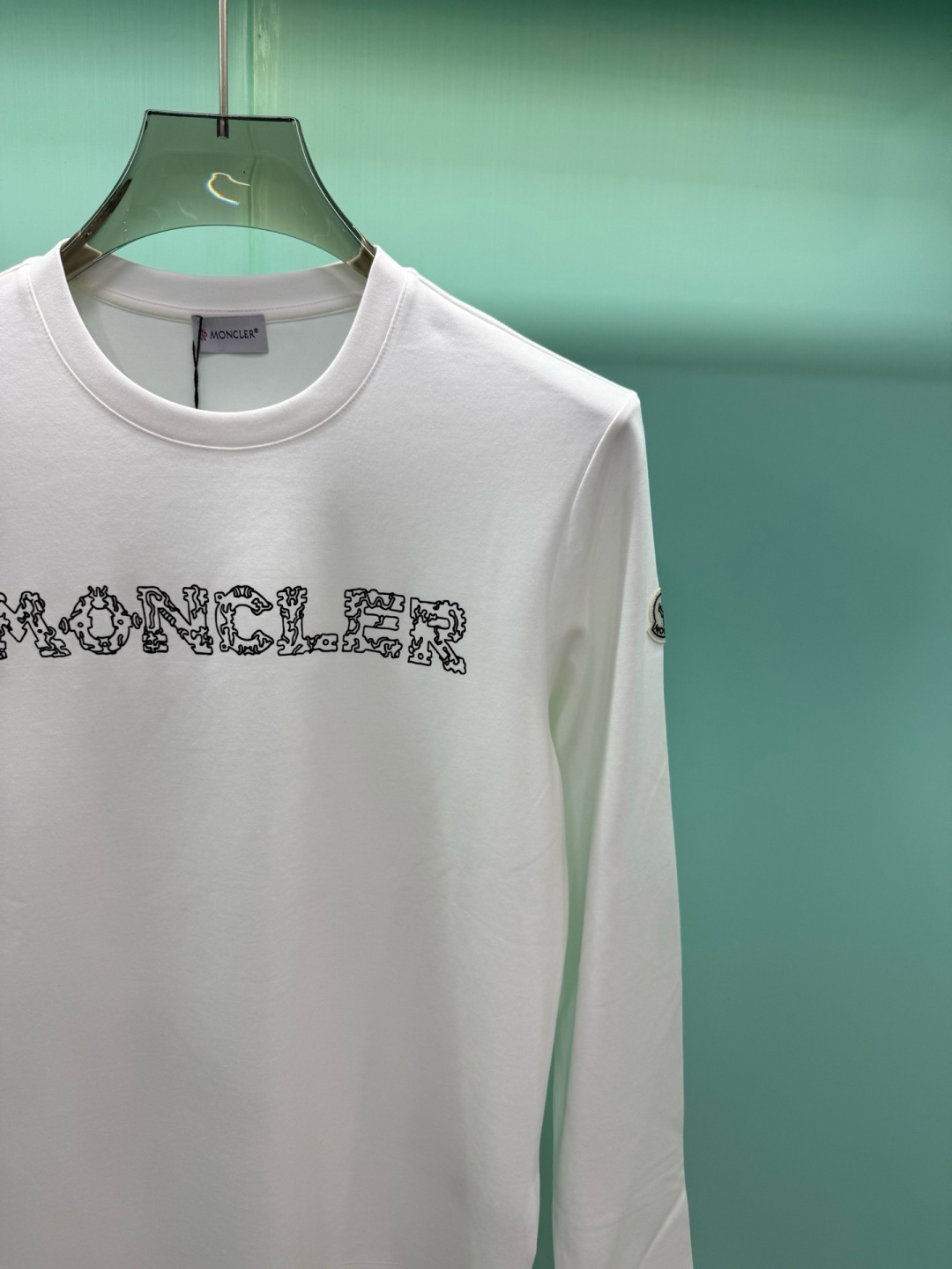 Moncler2026秋冬新品228克纯棉镂空印花工艺​​经典款字母长袖T恤，设计简约但细节感十足，适合追求低调质感的穿