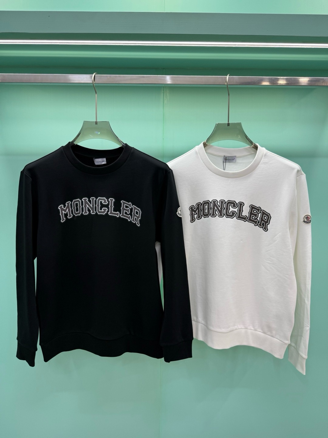 Moncler2026秋冬新品品牌印花圆领卫衣，黑白双色均为品牌标志性设计，胸前采用独特的拱形字母印花，胸前"MONCL