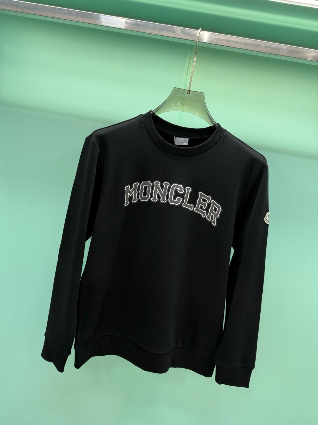 Moncler2026秋冬新品品牌印花圆领卫衣,黑白双色均为品牌标志性设计,胸前采用独特的拱形字母印花,胸前"MONCL Moncler2026秋冬新品品牌印花圆领卫衣,黑白双色均为品牌标志性设计,胸前采用独特的拱形字母印花,胸前"MONCL