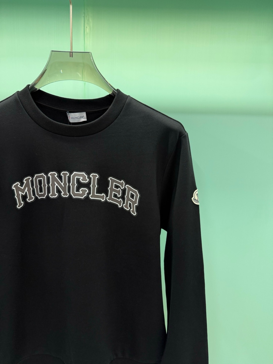 Moncler2026秋冬新品品牌印花圆领卫衣,黑白双色均为品牌标志性设计,胸前采用独特的拱形字母印花,胸前"MONCL Moncler2026秋冬新品品牌印花圆领卫衣,黑白双色均为品牌标志性设计,胸前采用独特的拱形字母印花,胸前"MONCL