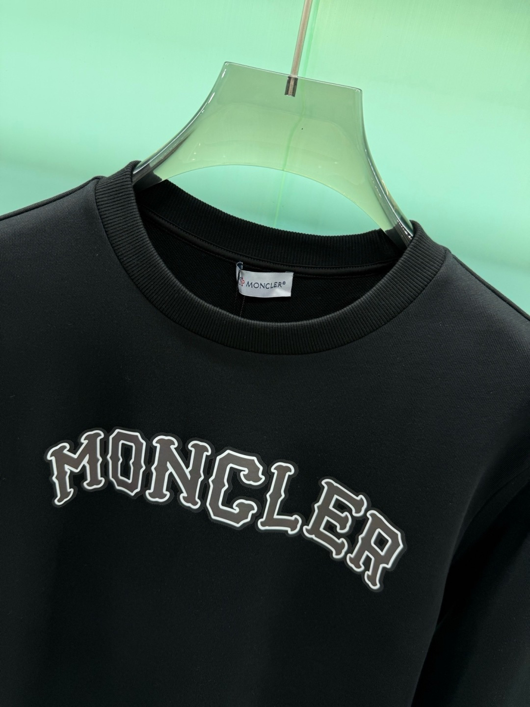 Moncler2026秋冬新品品牌印花圆领卫衣,黑白双色均为品牌标志性设计,胸前采用独特的拱形字母印花,胸前"MONCL Moncler2026秋冬新品品牌印花圆领卫衣,黑白双色均为品牌标志性设计,胸前采用独特的拱形字母印花,胸前"MONCL