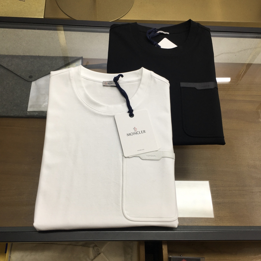 NO:911213,New counter product [MONCLE...] 2026 spring and summer new counter round neck short-sleeved fabric is made of Xinjiang long-staple cotton, with fiber length and strength far exceeding that of ordinary cotton. The fabric is anti-pilling, anti-stretching, and breathable and sweat-absorbent, making it suitable for summer wear. The woven fabric has both softness and stiffness, and is not too thin. At the same time, it retains the 'silky smooth' touch of long-staple cotton and is highly skin-friendly.  The brand's unique logo is sewn on the chest of this T-shirt, showing its simple and low-key charm. The exquisite brand letter logo on the pocket makes the overall low-key yet ingenious design. Code number 48 50 52 54 56 Color black white, T-shirt, tees, t-shirt,19860909专柜新品【MONCLE...】 2026春夏专柜新品圆领短袖 面料采用新疆长绒棉,纤维长度和强度远超普通棉,面料抗起球、抗拉伸,且透气吸汗,适合夏季穿着.织出的面料兼具柔软度与挺括感,不会过于单薄,同时保留长绒棉“丝绸般顺滑”的触感,亲肤性强. 这款T恤胸前缝制品牌独特标,彰显简约低调的魅力.精美的口袋品牌字母logo,整体低调又不失设计巧思.  码数48 50 52 54 56 颜色黑色 白色,,T-shirt,tees，t-shirt,,Men's clothing