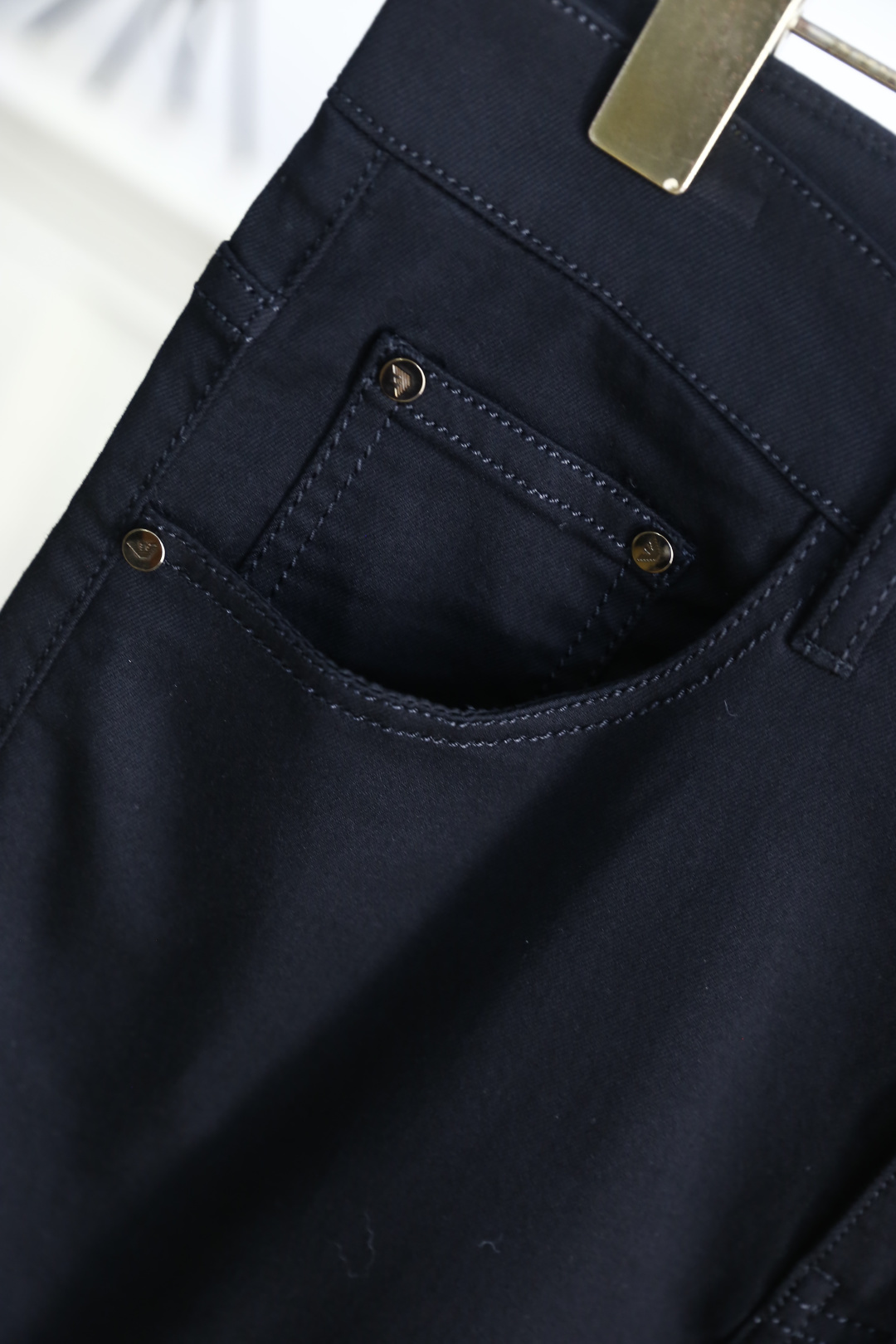 🔥阿玛尼.26夏季新品！男士经典黑色休闲裤承袭意式轻奢格调，后袋以立体鹰标与三色元素点缀，呼应品牌经典基