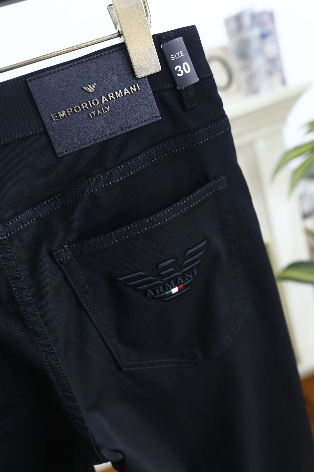 🔥阿玛尼.26夏季新品！男士经典黑色休闲裤承袭意式轻奢格调，后袋以立体鹰标与三色元素点缀，呼应品牌经典基
