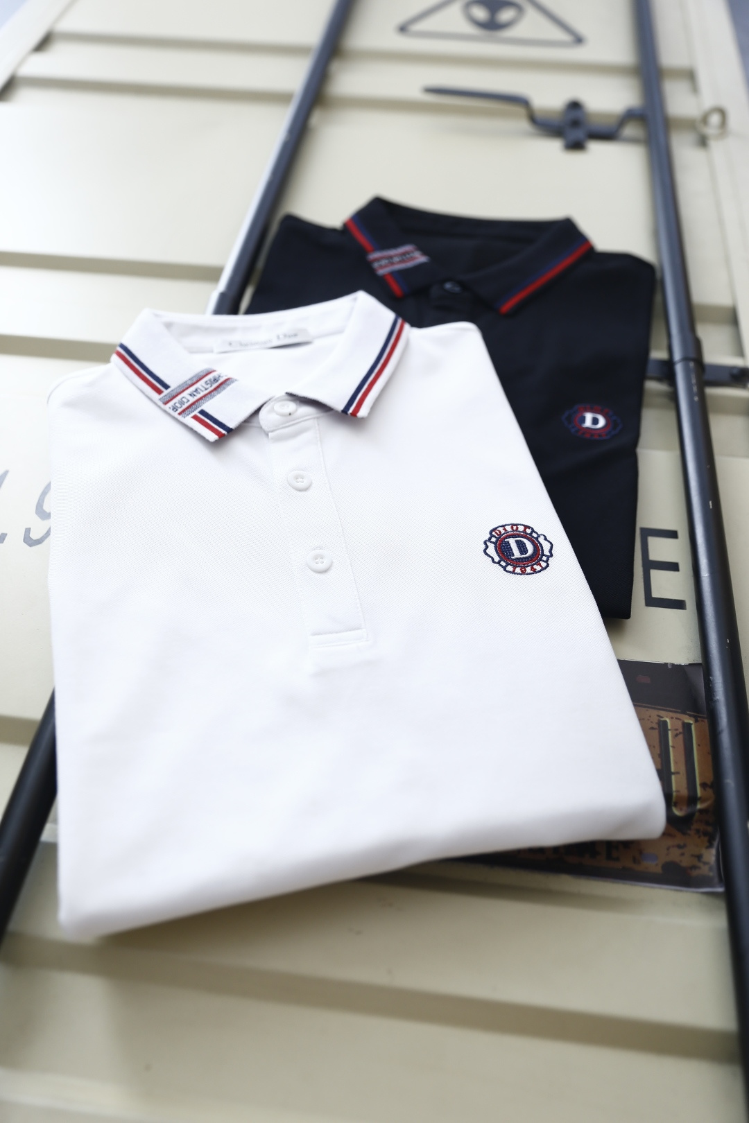 🔥迪奥.26夏季新品！时尚男士百搭短袖👍利落剪裁勾勒合身廓形，挺括翻领饰有品牌织带与撞色线条，胸口点缀精