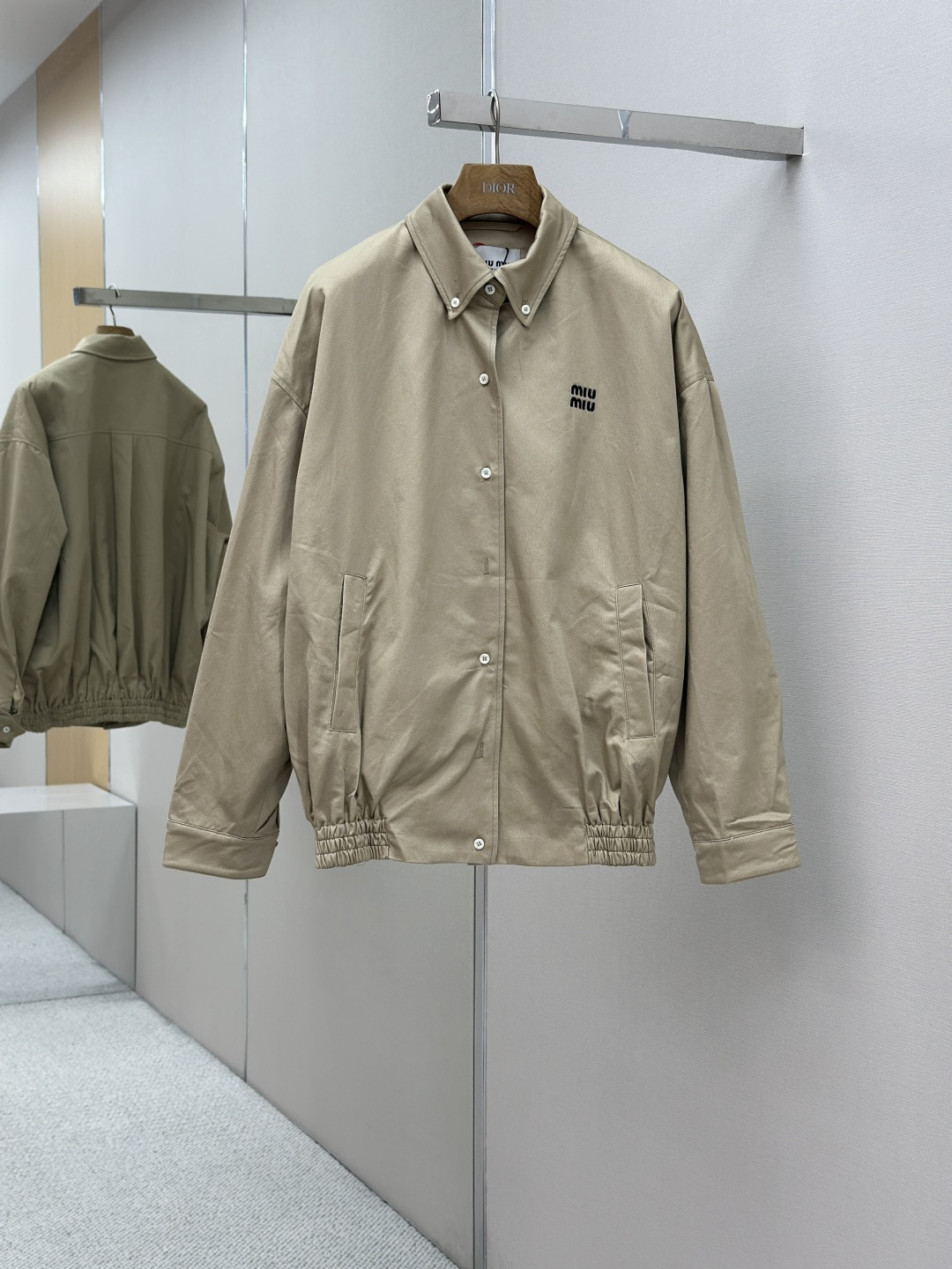 NO:510027,Mainly recommended MIIUMIU 25SS embroidered button jacket Customized dyed double-screw pattern luxury materials and cotton-shiny silk-patterned lining. Warm and mellow, soft and smooth, comfortable skin. Khaki as the background. Soft and unrevealed. The embroidered MiuMiu letter logo in the garment room is like a secret noble badge. Simple but recognizable. Hem tightening design adds a bit of playful and flexible classic button shirts. The casual and unrestrained jacket. A unique and charming fashion masterpiece came into being. Craft 1 uses imported machine embroidery technology. Use advanced computer control systems and precise mechanical components to achieve MiuMiu embroidery operations. High precision. Fluid and delicate lines. Craft 2: Template opening. Preset templates to guide the position of the bag. Shape and size. Accuracy ensures the quality of the bag opening effect.  Craft 3: The hem is made of a three-needle waist puller machine at one time. Using the machine's special needle position and feeding mechanism, the elastic band and the fabric are sewn together in the same process. The three-needle design is more firm. The pressure can be distributed evenly to ensure that the elastic band and the fabric are closely matched. Craft 4: The fabric is washed with sand. The texture is better. It is not easy to deform. It is not easy to shrink. It is not easy to fade. Maintain long-term beauty. Auxiliary material customization Miu Miu matte real shell buckle Customization Miu Miu trademark. Size loose pattern. Size 36 38 40 42,,miumiu,jackets & coats,shirts,alexander wang19860909主推 MIIUMIU 25SS刺绣系扣式夹克 定制定染双梭幻纹奢料 以及棉韵天丝素纹里衬布 温润醇厚 柔软丝滑 舒适贴肤 以卡其色为底色 柔和且不张扬 衣间的刺绣MiuMiu字母徽标 如同一枚隐秘的贵族徽章 简约却极具辨识度 下摆收紧设计 增添了几分俏皮与灵动经典系扣式衬衫的优雅邂逅夹克的随性不羁 一件独具魅力的时尚佳作应运而生 工艺1采用进口机刺绣工艺 使用先进的计算机控制系统和精密的机械部件 实现MiuMiu刺绣作业 精度高 线条流畅而细腻 工艺2: 模版机开袋 预设的模板来指导开袋的位置 形状和大小 精确性确保了开袋效果质量 工艺3: 下摆采用三针像筋拉腰机一次而成 利用机器的特殊针位和送料机构 将松紧带与布料在同一工序中缝合在一起 三针的设计更加牢固 能够均匀地分布压力 确保松紧带与布料紧密贴合 工艺4: 面料都经过砂洗 手感质感更佳 不易变形 不易缩水 不易褪色 保持长久的美观 辅料定制 Miu Miu 哑光真贝壳扣 定制 Miu Miu 商标 版型 宽松版型 尺码 36 38 40 42,,miumiu,jackets & coats,shirts,alexander wang,Men's clothing