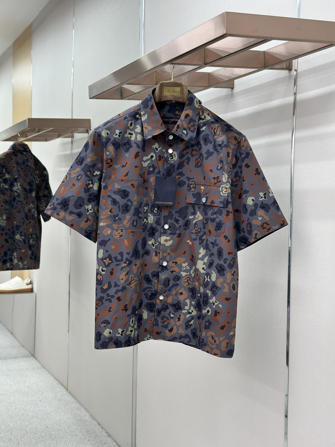 NO:857273,LOUIS VUITTON floral camouflage print short-sleeved shirt  Made of high-count cotton blended functional fabric, the texture is tough and crisp, and feels soft and skin-friendly. It has good wrinkle resistance and breathability. It will not deform after long-term wear and is refreshing and non-sticky when worn in summer. The body adopts an innovative fusion of the classic LV logo and camouflage elements. The dark camouflage texture is staggered and intertwined, and the color levels are rich and low-key.  Luxurious details are hidden to easily create a unique aura that combines street fashion and light luxury style; the classic pointed collar is paired with a chest pocket design, which is casual without losing the sense of drop; the buttons of the same color are customized at the placket, which opens and closes smoothly and is exquisite and durable; high-precision positioning printing technology is used in the garment process, and the pattern has strong adhesion and will not fade after washing.  Material: Cotton Loose fit Color matching Size SMLXL,,louis vuitton,louis vuitton,louis vuitton,shirts,T-shirt,19860909LOUIS VUITTON路易花卉迷彩印花短袖衬衫 采用高支棉混纺功能性面料,质地坚韧挺括且触感软糯亲肤,兼具良好的抗皱性与透气性,久穿不变形且夏日穿着清爽不粘身；衣身采用经典LV标识与迷彩元素的创新融合,暗纹迷彩肌理错落交织,色彩层次丰富且低调中暗藏奢饰细节,轻松营造兼具街头潮流与轻奢格调的独特穿搭气场；经典尖领搭配胸袋设计,随性中不失利落感,门襟处定制同色系纽扣,开合顺滑且精致耐看；成衣工艺上采用高精度定位印花技术,图案附着力强久洗不褪色. 材质: 棉 版型宽松 颜色拼色 尺码SMLXL,,louis vuitton,louis vuitton,louis vuitton,shirts,T-shirt,,Men's clothing