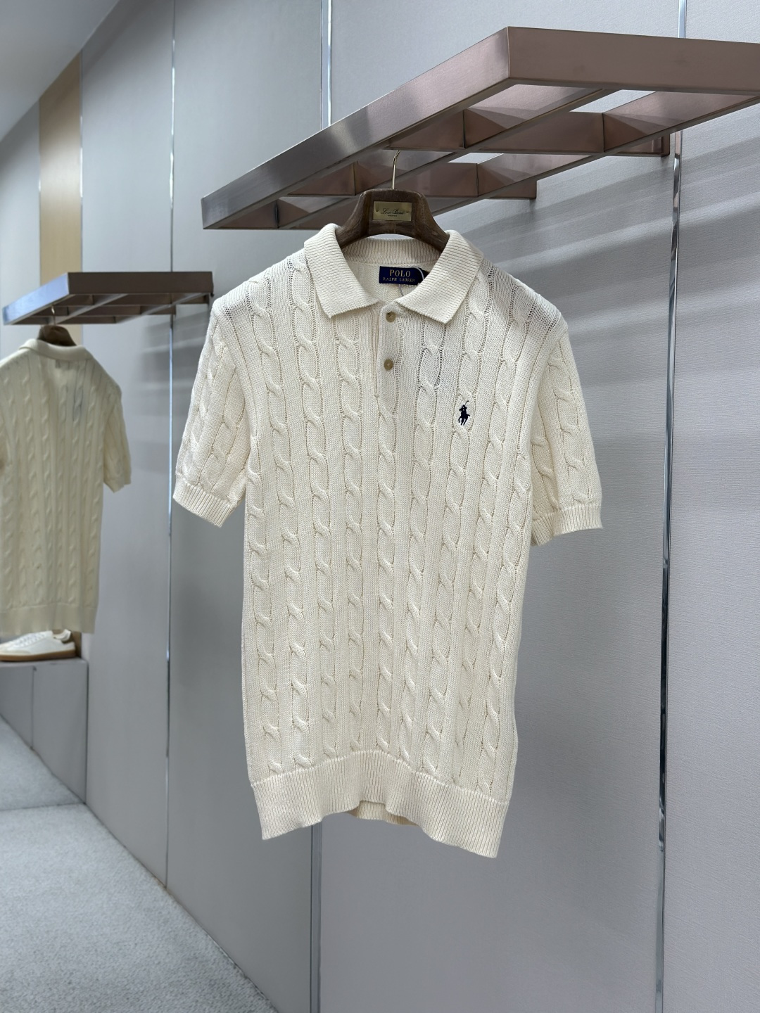 NO:857177,RL Ralph Lauren Cable Knit Short Sleeve Polo Shirt  The main body of the garment is made of high-count knitted wool blend fabric. The fabric has been processed through multiple pre-shrinking and softening processes. It feels delicate, soft and skin-friendly without any irritation. The upper body fits the skin without being tight. The overall fabric texture is tight and smooth, with a high-grade matte soft texture, which has outstanding  Breathable and sweat-wicking performance, long-term wear in spring and summer will not make you sweaty and sticky. It also has excellent anti-wrinkle and wear-resistant properties. It is not easy to deform, pill, fade or turn yellow after repeated washing, ensuring the high-end quality and long-term wearing value of the clothing from the root; the neckline adopts a classic lapel Polo collar  Shape-shaped design, with built-in double thread reinforcement technology in the collar, it is not easy to loosen and deform after being worn and washed many times, and the lines are smooth and neat, which not only softens the neck line, but also injects a retro college style into the simple body; the body adopts the iconic three-dimensional cable knitting process, and the hand-woven twist texture pattern  The path is full and three-dimensional, and the concave and convex weave has a high-end light and shadow texture, which greatly enhances the design recognition and retro atmosphere of the item. The placket is equipped with textured buttons of the same color, which opens and closes smoothly and is durable. The cuffs and hem are ribbed with moderate elasticity and will not easily become loose and deformed.  Material: Knitted. Slightly loose fit. Color: solid black, off-white. Size: SMLXL, T-shirt,19860909RL拉夫劳伦绞花针织短袖Polo衫  采用高支针织羊毛混纺面料打造衣身主体,面料经过多道预缩与柔化工艺处理,触感细腻软糯亲肤无刺痒感,上身贴合肌肤不紧绷；整体面料肌理紧致平整,自带高级哑光柔光质感,具备出众的透气排汗性能,春夏穿着久穿不易闷汗黏身,同时具备出色的抗皱耐磨属性,反复洗涤不易变形起球、不易褪色发黄,从根源保障服饰的高端品质与长期穿着价值；领口采用经典翻领Polo领型设计,领部内置双车线加固工艺,多次穿洗不易松垮变形,线条流畅利落,既柔和修饰颈部线条,又为简约衣身注入复古学院格调；衣身采用标志性立体绞花针织工艺,手工织就的麻花肌理纹路饱满立体,凹凸有致的织法自带高级光影质感,大幅提升单品的设计辨识度与复古氛围感；门襟搭配同色系质感纽扣,开合顺滑耐用,袖口与下摆均采用罗纹收边工艺,弹力适中不易松垮变形. 材质: 针织 版型微宽松 颜色纯黑色米白色 尺码SMLXL,,T-shirt,,Men's clothing