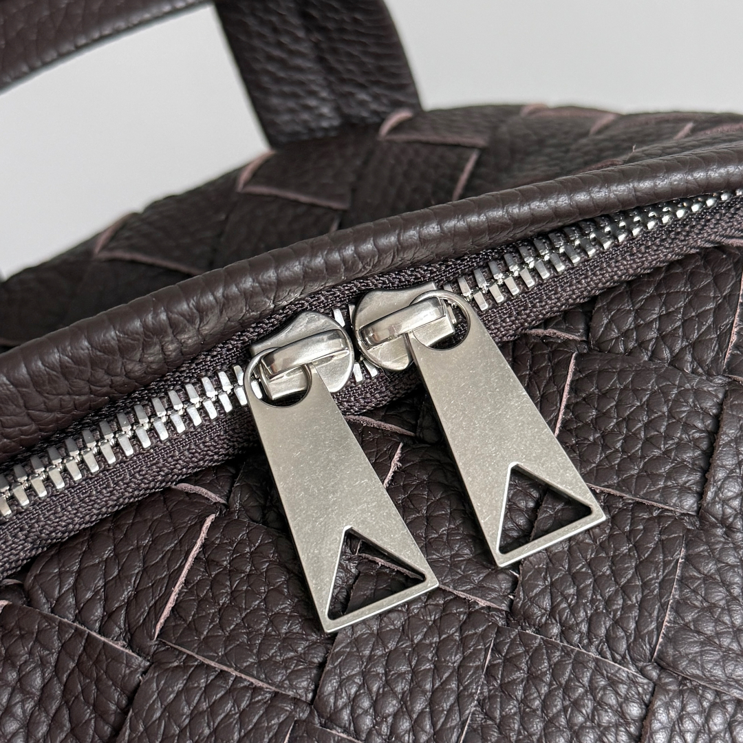 BOTTEGA VENETA 的这款 Intrecciato 编织双肩包，延续品牌经典匠心💼 独特的编织工艺，将皮革幻化成细腻纹理，似艺术雕塑般精致。它外观简约却自带高级辨识度，大容量空间适配办公通勤，装得下文件、数码设备，也能容纳日常小物。不管是搭配正装穿梭职场，还是休闲出行，都用 BV（Bottega Veneta）式的优雅与实用，诠释“经典永不过时”，背上它，每一步都走成品味的彰显✨。
款号：833158（730732）
尺寸：30*46*14cm