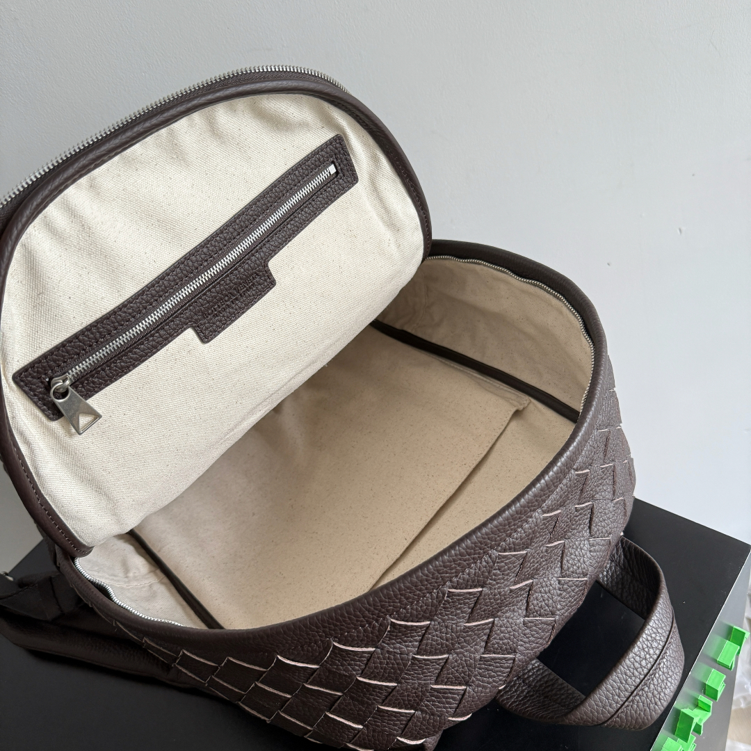 BOTTEGA VENETA 的这款 Intrecciato 编织双肩包，延续品牌经典匠心💼 独特的编织工艺，将皮革幻化成细腻纹理，似艺术雕塑般精致。它外观简约却自带高级辨识度，大容量空间适配办公通勤，装得下文件、数码设备，也能容纳日常小物。不管是搭配正装穿梭职场，还是休闲出行，都用 BV（Bottega Veneta）式的优雅与实用，诠释“经典永不过时”，背上它，每一步都走成品味的彰显✨。
款号：833158（730732）
尺寸：30*46*14cm
