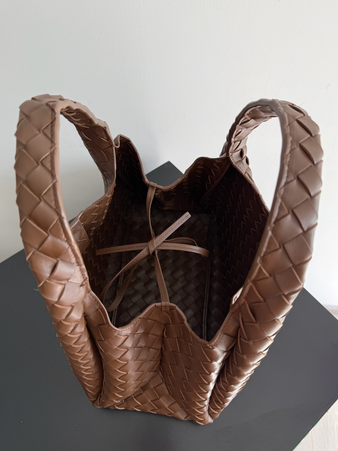 新品来袭！BOTTEGA VENETA葆蝶家2025新品Campana肩背包上市啦~首先夸夸这款包包的自重，作为一款不算很小的包包，它非常的轻便日常，对于我这种出门需要携带很多随身物品的人来说这个优点真是太棒了，很大程度减轻了出行的负担🛍️在造型上有点像是parachute和jodie的结合体，钝钝的三角造型可爱憨厚，背出门逛街就是心情好的加速器，提手和包身都是经典编织，在原本的敞口设计上加了系带，如果没有系起来，包包拎起来就会有小菜篮的造型哦
款号：844249
尺寸：33*20*16.5cm