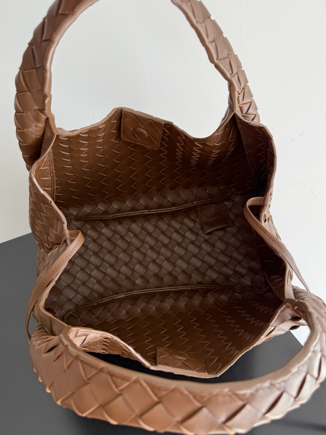 新品来袭！BOTTEGA VENETA葆蝶家2025新品Campana肩背包上市啦~首先夸夸这款包包的自重，作为一款不算很小的包包，它非常的轻便日常，对于我这种出门需要携带很多随身物品的人来说这个优点真是太棒了，很大程度减轻了出行的负担🛍️在造型上有点像是parachute和jodie的结合体，钝钝的三角造型可爱憨厚，背出门逛街就是心情好的加速器，提手和包身都是经典编织，在原本的敞口设计上加了系带，如果没有系起来，包包拎起来就会有小菜篮的造型哦
款号：844249
尺寸：33*20*16.5cm