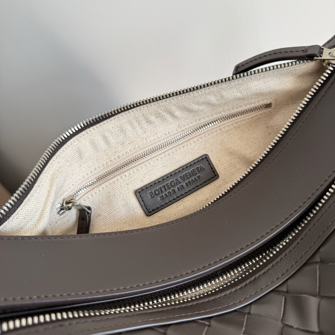 🎁BOTTEGA VENETA新品编织Tribeca手提包  双拉链设计+内里分层超清晰，容量够还不乱糟糟；日常通勤、短途出行，小物件都能有序收纳🗂搭配舒适宽肩带，单肩、斜挎、手拿随心换，背法超灵活，斜挎随性、手拎干练，轻松拿捏不同场合格调🎯上班通勤或周末休闲都能穿出高级感，实用度直接拉满💯做旅行包包也可以！
款号：836016
尺寸：30.5*20*9cm
颜色：黑棕色