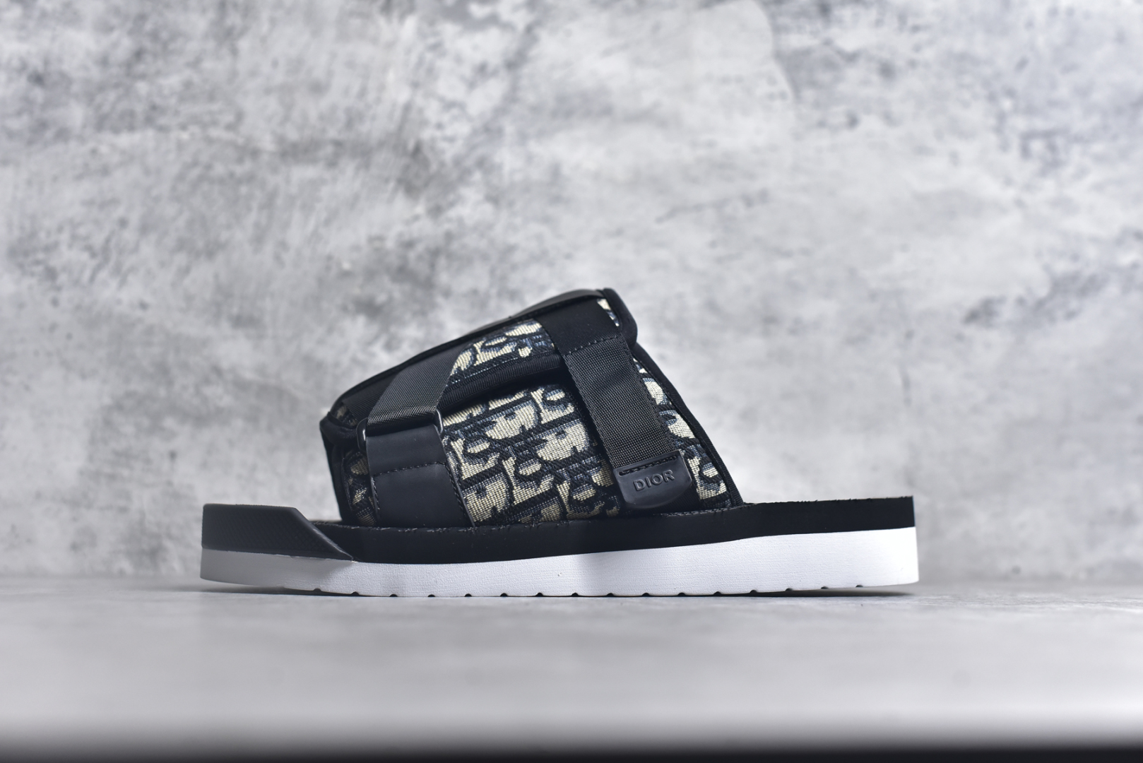 #x1Dior 迪奥 Alpha Obique 电绣时尚拖鞋 此款包头拖鞋特色在于采用米色和黑色 Dior Oblique 经典传统采用电绣提花辨识度很高 该图案最初于 1967 年引入。这款凉鞋采用结实的双色橡胶鞋底，搭配黑色尼龙饰带，侧面饰以“Dior”徽标，正面橡胶拼接保护鞋头。可搭配牛仔裤或长裤穿着，提升休闲服饰的格调 尺码：38 39 40 41 42 43 44 45 46-选品中心