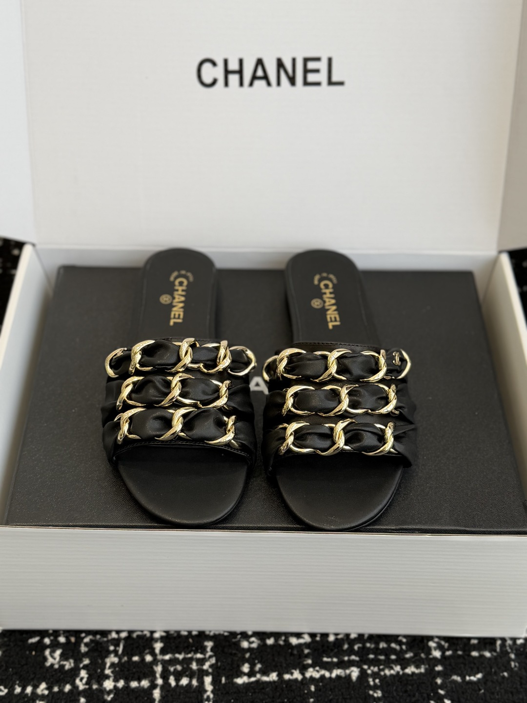 NO:707299,Purchasing agent grade (Official website sync box packaging) Chane*26ss spring and summer new flat-soled Mule slippers are all open-toe high-heeled Mule slippers without heel style, easy to put on and take off with one foot; the heel is a stiletto design, which enhances the leg line while retaining the casual feel of Mule slippers, suitable for daily and light social scenes.  The insole of the shoe is printed with the golden 'CHANEL' brand logo, and the body of the shoe is embellished with the classic double-C metal buckle to enhance brand recognition; the details of different material models have different emphases, the diamond-faced model has a strong luster, while the mesh model adds a soft and delicate feel. Sheepskin upper, sheepskin lining, genuine leather outsole size 35-41 (customized sizes 40 and 41 are non-returnable), slippers, chanel, slippers, sheepskin, Leather soles19860909代购级（官网同步盒包装） Chane*26ss春夏新款 平底 穆勒拖鞋 均为露趾高跟穆勒拖无后跟款式,一脚蹬穿脱便捷；鞋跟为细高跟设计,提升腿部线条的同时保留了穆勒拖的休闲感,适配日常与轻社交场景. 鞋内底印有金色“CHANEL”品牌标识,鞋身点缀经典的双C金属扣,强化品牌辨识度；不同材质款的细节装饰各有侧重,钻面款光泽感强,网纱款则增添柔美精致感. 鞋面羊皮 内里羊皮 大底真皮大底 size35-41码（40、41码定制不退换）,拖鞋,chanel,slippers,sheepskin,Leather soles,Women's Shoes