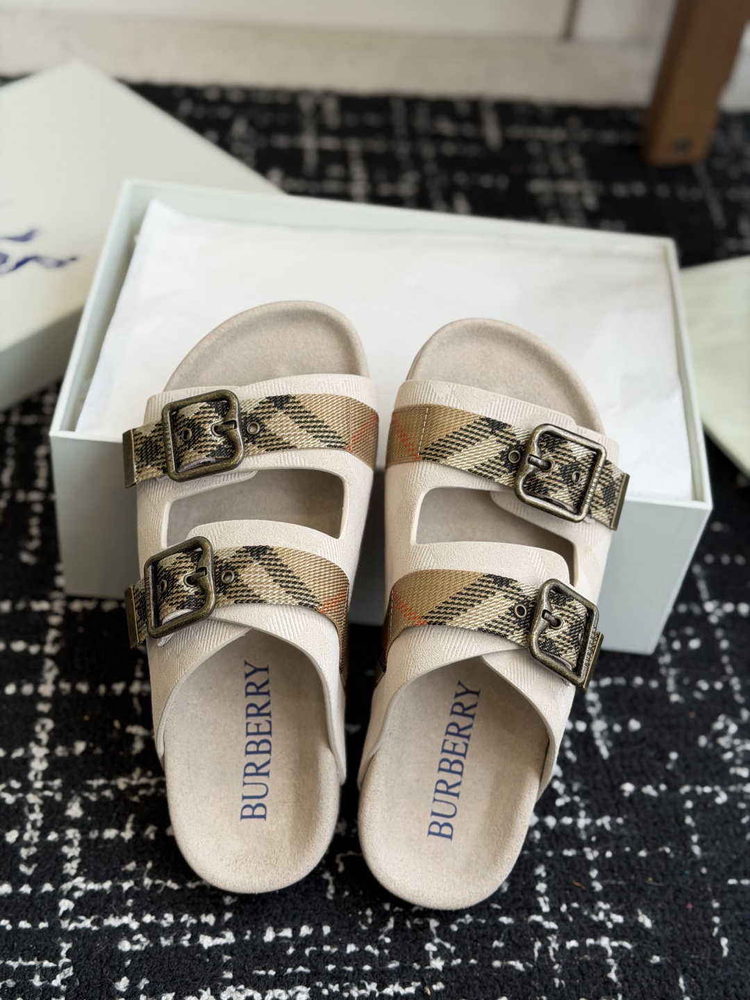 东莞代购级BURBERRY 格纹双扣一字拖 品牌经典格纹织带搭配做旧金属方扣，复古腔调直接拉满。鞋面采用