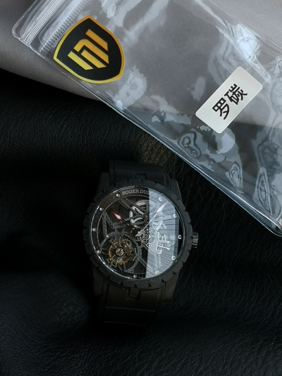 NO:755020,'NEW Factory' Roger Dubuis Carbon Fiber V4 Edition Tourbillon. Special instructions!  !  !  The hollow frame structure inside the movement!  Watch lovers all know that movement is the most critical and core technology of watches!  In order to allow all watch friends to play the top replica tourbillon, the watchmakers of the new factory have experimented countless times to overcome all existing technical barriers!  The frame is hollowed out with double-layer plywood to achieve stability and precision. The V4 version movement is more perfect and has the same mechanism as the genuine RD505SQ!  2: Overall upgrade of the watch case. Carbon fiber is a high-tech material that is only half the weight of aluminum but three times as strong!  The entire carbon fiber pattern of the V4 version case is clearer and more refined, not only has a light and comfortable wearing experience, but the special dark pattern texture is even more cool. 3: Natural rubber strap, each strap fits perfectly with the lugs, giving the wrist the highest comfort. 4: The buckle is made of titanium vacuum electroplated high-grade black, which is durable and does not fade; every ultimate detail is the sincerity of NEW's ingenuity, Roger Dubuis choose New Factory!  'NEW Factory' achieves new breakthroughs and treats watch lovers with 'heart'!  ,,roger19860909『新厂-NEW Factory』罗杰杜彼碳纤维V4版 陀飞轮. 特别说明！！！ 机心内部镂空框架结构！爱表人士都知道机芯是手表最关键与核心技术！为了让各位表友玩到顶级复刻版陀飞轮,新厂制表师实验无次数.才能克服一切存在的技术壁垒！框架试镂空双层夹板,做到即稳定,又精细,V4版本机芯更加完美、完全与正品RD505SQ相同机构！ 2:表壳整体升级 碳纤维是一种高科技材料,重量只有铝的一半,强韧度却是其三倍！V4版表壳整个碳纤维纹路更加清晰精致,不仅拥有轻盈舒适的佩戴体验,特殊的暗黑花纹质感更是炫酷十足. 3:天然橡胶表带,每条表带与表耳完美契合,给予手腕最高的舒适度. 4:表扣采用钛金属真空电镀高级黑,坚固耐用不掉色；每个极致的细节都是NEW匠心开发的诚意,罗杰.杜彼就选新厂！ 『新厂-NEW Factory』实现新突破,用“心”对待腕表爱好者！,,roger,Watch