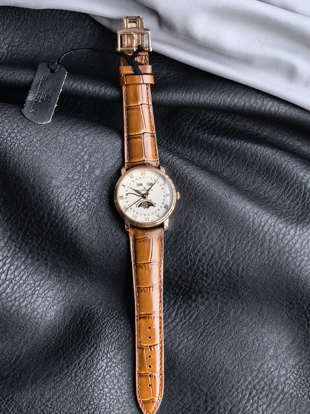 NO:947095,GR Factory's new Blancpain Classic V Series Full Calendar Moon Phase Watch 6654N 1. Stepped case, simple yet three-dimensional, with a diameter of 40. 2. The dial details have been updated with Blancpain JB instead of Roman numerals at 12 o'clock, and the scales have been straight-line polished, which is more in line with modern aesthetics. 3. New luminous hands, large logo second hand, and blue steel calendar hand, all three perform their own duties. The 11 o'clock and 1 o'clock windows display the day of the week and the month.  Equipped with the 6654.5 self-winding movement, with a power reserve of up to 48 hours, a new hollow gold automatic rotor, and four-way hidden adjustment buttons cleverly integrated into the watch lugs, taking into account both convenient operation and aesthetic balance. Blancpain’s moon phase face was once talked about by watch friends, and its cute little face has the same effect as the emoji expression.  It is not only a tool to record time, but also an art treasure on the wrist, highlighting the noble temperament of the wearer. It can become the focus of attention in both business and leisure occasions.19860909GR Factory新品宝珀经典新V系列全历月相腕表6654N 1阶梯式表壳,简约中有立体感,表径40 2 盘面细节焕新12点用宝珀JB替代罗马字,刻度变成直线形打磨,更符合现代人审美. 3全新夜光指针、logo大秒针、蓝钢日历针,三者各司其职,11点位与1点位窗口,显示星期与月份. 搭载6654.5自动上链机芯,动力储存长达48小时,全新镂空金质自动陀,四方位隐藏式调校按钮巧妙融入表耳,兼顾便捷操作与美学平衡,宝珀的月相脸一度被表友们津津乐道,俏皮小脸与emoji表情有异曲同工之妙. 它不仅是记录时间的工具,更是腕间的艺术珍品,彰显佩戴者的尊贵气质,无论商务还是休闲场合,都能成为焦点,,Watch