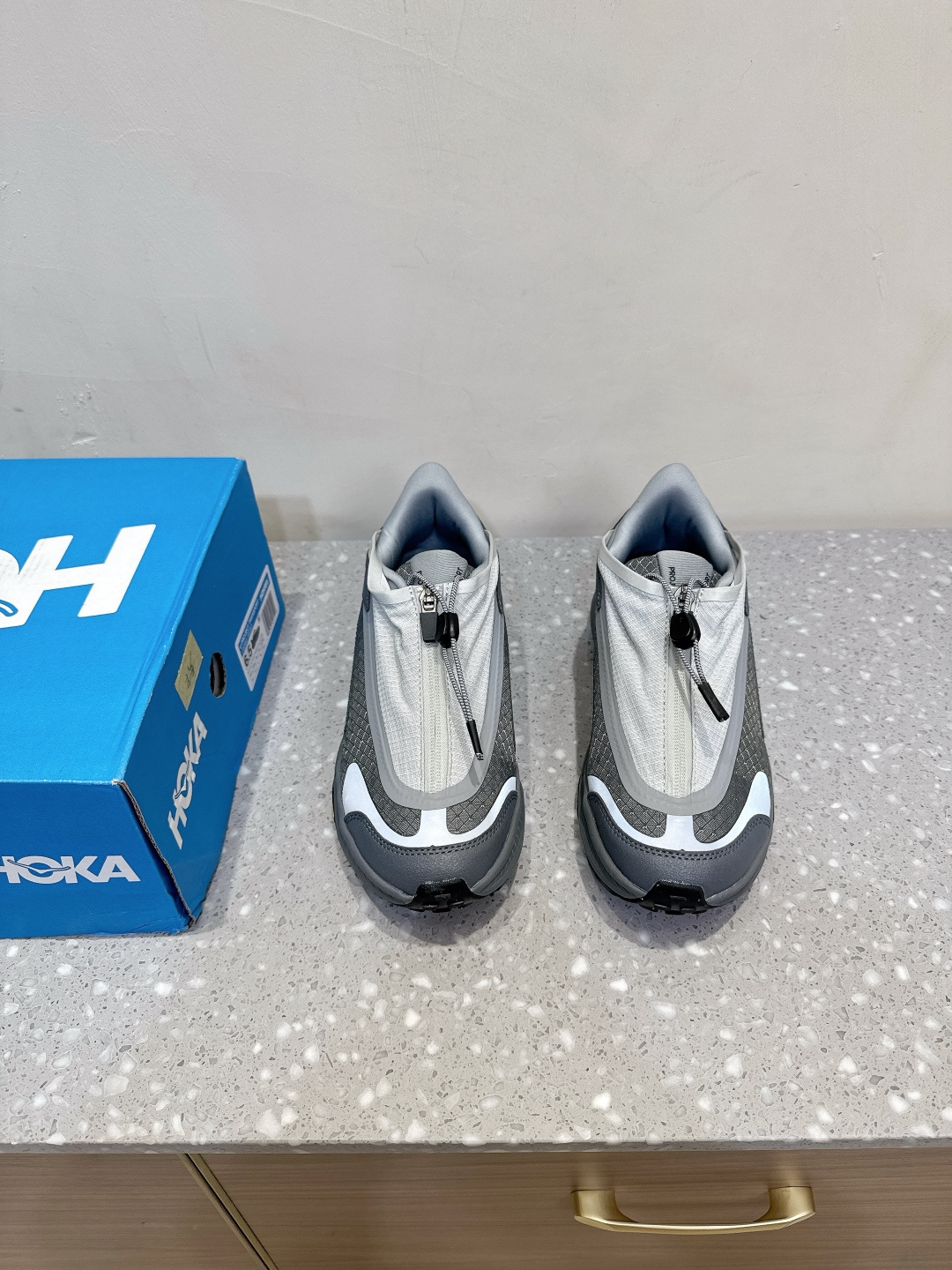 NO:475423,(Dongguan goods) HOKA ONE ONE PROJECT TRANSPORT versatile and comfortable, non-slip and wear-resistant, low-top, life and casual shoes, made of tear-resistant material and covered with synthetic leather, has a waterproof coating without PFC, which increases durability while being suitable for wearing in humid environments. The details of hot melt webbing further enhance durability. Equipped with a thick foam midsole, it provides good cushioning, increases wear comfort, and reduces the impact on feet and joints when walking or exercising. The Vibram Ecostep outsole provides excellent grip and stability in various weather conditions, suitable for a variety of terrain. The fast lace-up system has a waterproof covering on the top, and is paired with a zipper design to simplify the on-and-off process. It also prevents debris gravel from entering the reflective details of the upper, improving visibility at night or in low-light environments and increasing wear safety.  The shoe design is reasonable, the wide feet are comfortable to wear, and the interior space is sufficient, providing enough room for movement for the toes. The fashionable appearance can be matched with a variety of clothing, whether it is suit pants or casual wear, and is suitable for daily work, shopping and other occasions. Its anti-slip, wear-resistant, waterproof and good cushioning performance make it suitable for outdoor field tours, hiking and other activities. Size36 36.5 37 38 38.5 39 40 40.5 41 42 42.5 43 44 45 One size smaller, casual shoes/sports shoes, sneakers, business suit19860909（东莞货） HOKA ONE ONE PROJECT TRANSPORT 百搭舒适 防滑耐磨 低帮 生活休闲鞋 采用防撕裂材质并覆盖合成皮革,具有不含PFC的防水涂层,增加耐用性的同时,适合潮湿环境穿着,热熔织带细节进一步增强耐用性. 搭载厚泡棉中底,提供良好的缓震效果,增加穿着舒适性,减少行走或运动时对脚部和关节的冲击. Vibram Ecostep外底,在各种天气条件下提供卓越的抓地力与稳定性,适合多种地形.快速系带系统顶部带有防水覆盖层,搭配拉链设计,简化穿脱过程,还可防止杂物碎石进入鞋面的反光细节,提高了夜间或低光环境下的可见性,增加穿着安全性. 鞋型设计合理,宽脚穿着也舒适,内部空间充足,给脚趾提供足够活动空间. 时尚的外观可搭配多种服装,无论是西装裤还是休闲装都能轻松驾驭,适合日常上班、逛街等场合. 其防滑、耐磨、防水及良好的缓震性能,使其也适用于户外野游、徒步等活动. Size36 36.5 37 38 38.5 39 40 40.5 41 42 42.5 43 44 45偏小一码,休闲鞋/运动鞋,sneakers,business suit,Women's Shoes