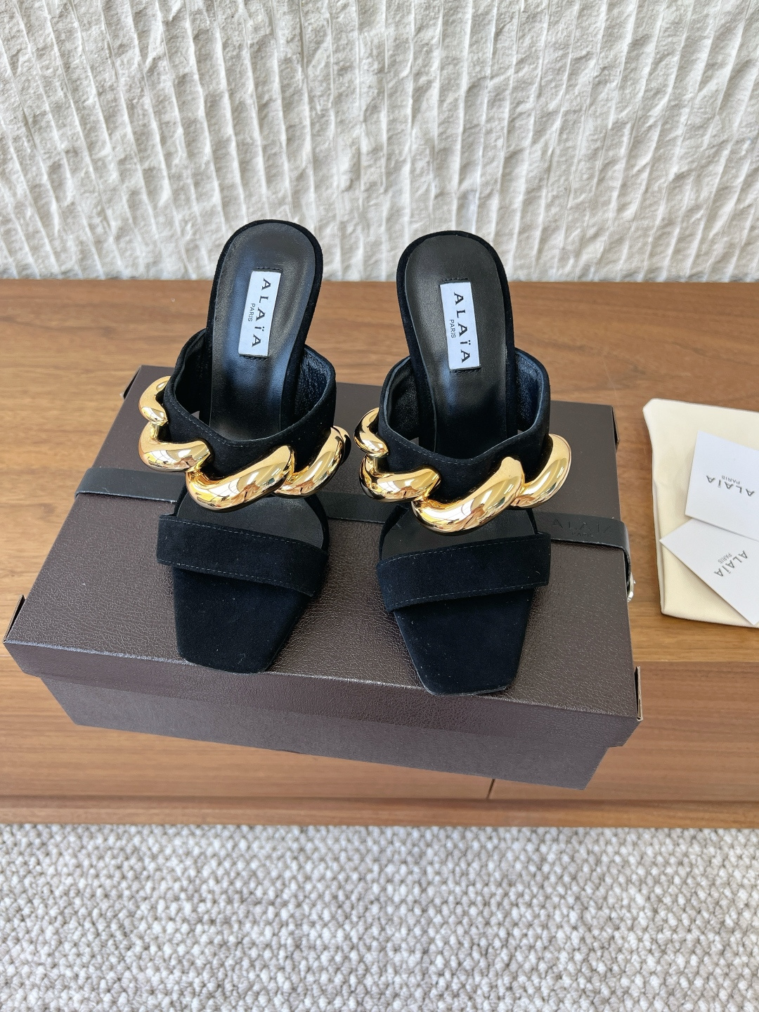 NO:751002,G902 ALAIA 26ss spring and summer new chain square toe cube wedge heel mule slippers This wedge mule shoe has a square toe design and a unique cube heel, made of fine sheepskin leather. It easily creates a fashionable and modern feel. Stripping away redundant decorations creates a minimalist and highly recognizable mule shoe silhouette. The neat thick heel perfectly combines aura and practicality.  As a daily interpretation of a haute couture house, it is not only a neat standard for commuting in the workplace, but also a lazy tool for dinner appointments. Every step is based on the precise scale of French avant-garde aesthetics. The upper is made of original imported sheep/cow leather, the lining is sheepskin, and the heel height is 10cm. The sole is original custom injection molded Italian leather outsole. Size35-39 (40.41.42 custom-made, non-returnable), high-heeled shoes and slippers, alaia, high  heels,slippers,cowhide,sheepskin,sheep,Leather soles19860909G902 ALAIA 阿莱亚 26ss春夏新款 链条 方头 立方体 坡跟 穆勒拖鞋 这款坡跟穆勒鞋,方头设计,搭配别具一格的立方体鞋跟,采用细腻羊猄皮制成. 轻松营造时尚摩登之感. 剥离冗余装饰 构筑出极简又极具辨识度的穆勒鞋廓形 利落粗跟将气场与实穿性完美融合 作为高定屋的日常化诠释 它既是职场通勤的利落标配 也是晚宴赴约的慵懒利器 每一步都踩在法式先锋美学的精准刻度上 鞋面采用原版进口羊猄/牛皮 内里垫脚羊皮 跟高10cm 鞋底原版定制注塑意大利真皮大底 Size35-39（40.41.42定做不退换）,高跟鞋拖鞋,alaia,high heels,slippers,cowhide,sheepskin,sheep,Leather soles,Women's Shoes