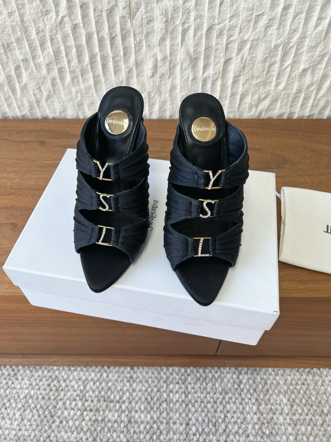 NO:757636,G902 Saint Laurent 26ss spring and summer new style, pointed toe, rhinestone inlay, logo silk, three straps, high heels, sandals. The main body of the shoe is made of high-density heavy silk. After special treatment, it presents an extremely restrained pearl luster between matte and satin. It is not as eye-catching as patent leather, but like the private and warm glow of silk under the dim light of a private box, which is skin-friendly, luxurious and full of narrative. Iconic  The 'YSL' Logo is not a simple metal nameplate, but is composed of hundreds of precision-cut top-grade Austrian crystals, paved according to the shape of the letters. The rhinestone inlay base is extremely thin, making it almost integrated with the silk upper, but when the light passes by, it suddenly bursts out with a cold and sharp bright light like broken ice. This signature is the calmest and most dazzling oath of luxury. The upper is made of original imported silk/cowhide and the lining is sheepskin.  Heel height 10cm, outsole, original custom-made Italian leather outsole, Size 35-39 (40.41.42 custom-made, non-returnable), high heels and slippers, saint laurent, saint laurent, high heels, slippers, cowhide, sheepskin, real silk, Leather soles19860909G902 Saint Laurent 26ss春夏新款 尖头 水钻镶嵌 logo真丝三带 高跟 凉拖 鞋身主体采用高密度的重磅真丝,经过特殊处理,呈现出一种介于哑光与缎光之间的、极为内敛的珍珠光泽. 不像漆皮般张扬夺目,而是如同在私人包厢昏暗灯光下,丝绸泛出的私密而温暖的光晕,亲肤、奢华且充满叙事感. 标志性的 “YSL” Logo 并非简单的金属铭牌,而是由数百颗精密切割的顶级奥地利水晶,依据字母形状密镶而成. 水钻的镶嵌底座极薄,使其几乎与真丝鞋面融为一体,却在光线掠过时,骤然迸发出冰冷、锐利如碎冰般的璀璨光芒.这道签名,是奢华最冷静、也最耀眼的宣誓. 鞋面采用原版进口真丝/牛皮 内里垫脚羊皮 跟高10cm 大底原版定制意大利真皮大底 Size35-39（40.41.42定做不退换）,高跟鞋拖鞋,saint laurent,saint laurent,high heels,slippers,cowhide,sheepskin,real silk,Leather soles,Women's Shoes