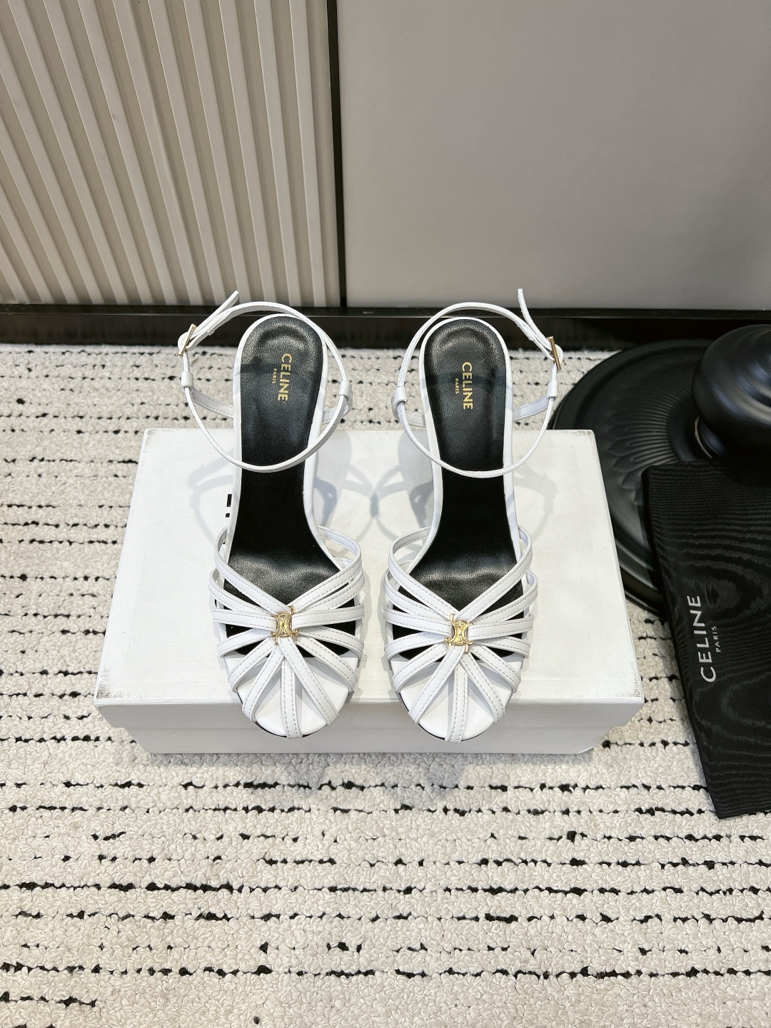 NO:884657,G912 CELIN* Triomph* white lambskin high-heeled sandals French hollow thin strap Roman shoes Who knows!  This pair of CELINE white sandals has 'French nobility' directly welded to the feet. The moment I got it, I was speechless by the metallic luster of the lambskin. It is so delicate that you can feel the cloud-like texture, and the luster under the sun is so high-end that you can feel it in your bones.  The woven cage-shaped toe is so recognizable, and the Triomphe metal buckle in the center is the finishing touch. It hides the brand's iconic Arc de Triomphe element just right, low-key and elegant. The 8.5cm slender heel comes with a leg-lengthening buff, and the adjustable buckle at the ankle fits perfectly, and it does not wear your feet after walking for a long time. Gold is really the god of summer!  Pair it with a little white skirt to look like a gentle young lady, or pair it with suit trousers to look like a smart workplace person. Even the cutouts on the feet give off a French sense of laziness. Wear it on a date or to a dinner party, and people will ask you if you have secretly changed your identity ■Cow leather upper layer ■Sheepskin for foot pads ■Genuine leather outsole ■size 35-39 (40.41 custom-made, non-returnable), sandals, celine, sandals, skirts, business  suit,cowhide,sheepskin,leather soles19860909G912 CELIN* Triomph*白色小羊皮高跟凉鞋 法式镂空细带罗马鞋 谁懂啊！这双CELINE白色凉鞋直接把「法式贵气」焊在脚上了 拿到手的瞬间就被这金属光泽的小羊皮美到失语,细腻到能摸出云朵般的质感,阳光下的光泽感高级到骨子里. 编织笼状鞋头太有辨识度了,中心的Triomphe金属扣是点睛之笔,把品牌标志性的凯旋门元素藏得恰到好处,低调又显贵.8.5cm的细跟自带拉长腿buff,脚踝的可调节扣带完美贴合,走久了也不磨脚. 金色真的是夏天的神！搭配小白裙是温柔大小姐,配西装裤就是利落职场人,连脚面的镂空都透着法式慵懒感. 穿上它去约会、参加晚宴,别人都得问你是不是偷偷换了新身份 ■鞋面头层牛皮 ■垫脚羊皮 ■大底真皮大底 ■size35-39（40.41定做不退换）,凉鞋,celine,sandals,skirts,business suit,cowhide,sheepskin,Leather soles,Women's Shoes