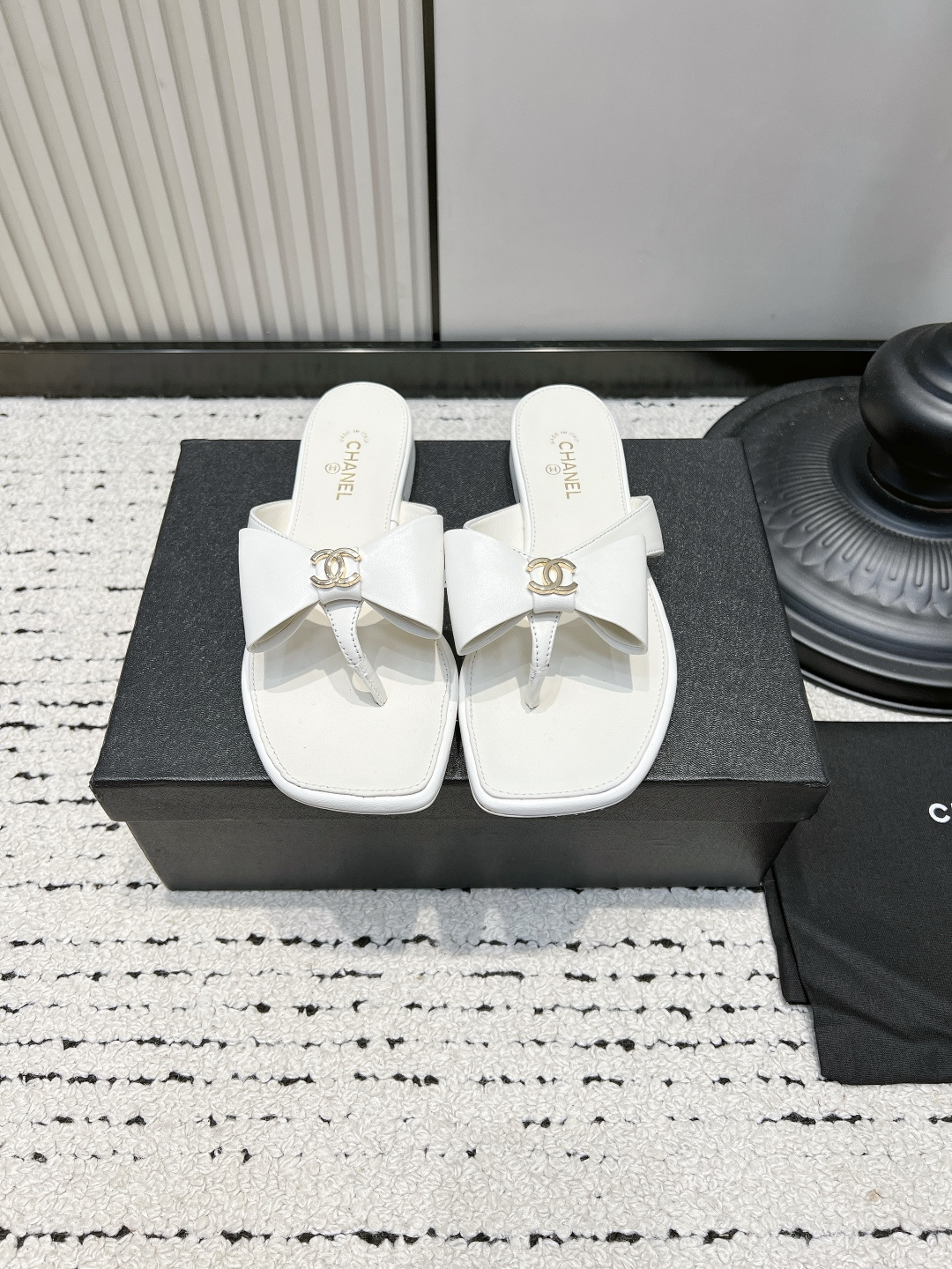 NO:921386,Chanel26ss new summer square-toe bow-knot flip-flops are square-toe bow-tie flip-flops with a lazy, luxurious and casual atmosphere. The neat square-toe shoe shape is matched with a delicate bow ribbon. The flip-flop has a simple and elegant herringbone structure. The center of the ribbon is embellished with a metal logo. The flat-bottomed version has smooth lines and a spacious shoe compartment, making it easy to handle wide and narrow feet.  Suitable for various colors in the wardrobe for casual, commuting, and vacation, regardless of skin color. Taking into account the noble appearance and practicality in summer, if you want a pair of simple, exquisite, versatile and durable flip-flops, this square-head bow flip-flop is an essential item for the summer shoe cabinet. ■Sheepskin upper/sheep suede ■Sheepskin lining ■Genuine leather outsole  ■size 35-41 (customized sizes 40 and 41 are non-refundable), split-toe shoes, chanel, slippers, sheepskin, Leather soles19860909Chanel26ss夏季新款方头蝴蝶结夹趾人字拖 自带慵懒轻奢休闲氛围感的方头蝴蝶结夹脚人字拖,利落方头鞋型搭配精致蝴蝶结饰带,夹脚人字结构简约大气,饰带中央点缀金属标识,平底版型线条流畅,鞋仓空间宽松舒展,宽窄脚型都能轻松驾驭. 适配衣柜里休闲、通勤、度假各类色系穿搭,不挑肤色.兼顾显贵颜值与夏日实穿性,想要一双简约精致、百搭耐看的夹脚拖鞋,这款方头蝴蝶结人字拖是夏日鞋柜的刚需单品. ■鞋面羊皮/羊反绒 ■内里羊皮 ■大底真皮大底 ■size35-41码（40、41码定制不退换）,分趾鞋,chanel,slippers,sheepskin,Leather soles,Women's Shoes