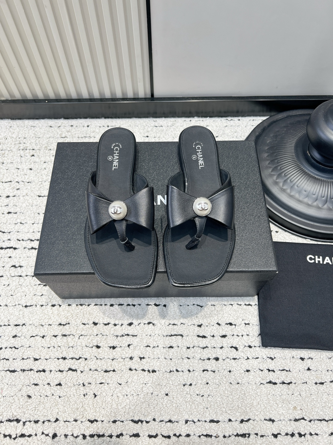 NO:921975,Chanel Chanel Bow Pearl Flip Flop Women's Square Toe Flat Flip Flop Chanel's flip flops are really about aesthetics!  The center of the bow is inlaid with pearls, and the inside is engraved with the classic double C logo, which adds a sense of sophistication. The improved square toe shape modifies the foot shape without squeezing the toes. The flat soft insole makes the upper foot light and comfortable, and the feet are not tired after walking for a long time. It is super atmospheric when paired with shorts, dresses, and skirts for daily use. Suitable for vacation, shopping, and commuting, it is low-key and elegant, a must-have item in summer!  ■size35-40 (40 is custom-made and cannot be returned or exchanged), split-toe shoes, chanel, chanel, skirts, shorts19860909Chanel香奈儿蝴蝶结珍珠人字拖女 方头平底夹趾凉拖 香奈儿这款人字拖真的长在了审美点上！ 蝴蝶结中心镶嵌珍珠,内里刻印经典双C标识,精致感直接拉满. 改良方头版型,修饰脚型,不会挤压脚趾. 平底软鞋垫,上脚轻盈舒适,长时间走路也不累脚. 日常搭配短裤、连衣裙、半裙都超有氛围感. 度假、逛街、通勤都适配,低调又显贵,夏日必备单品！ ■size35-40（40定做不退换）,分趾鞋,chanel,chanel,skirts,shorts,Women's Shoes