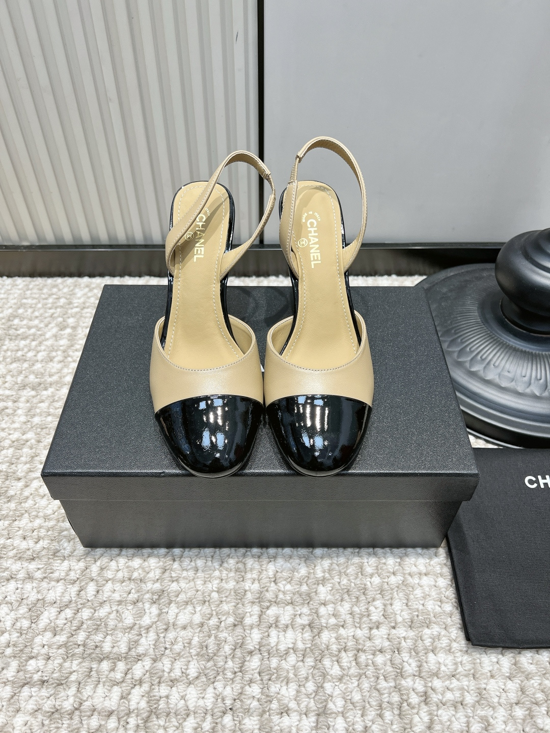 NO:958630,G081 CHANEL nude black color block round toe stiletto heel sandals 26ss classic two-color splicing | versatile and timeless for commuting. Light apricot matte cowhide with shiny black patent leather toe is Chanel's iconic color block design. The retro round toe accommodates the toes without squeezing the foot; the slender high heel elongates the leg line, the small red embellishment at the heel hides ingenuity, and the back strap is refreshing and breathable.  It is suitable for matching with suit skirts, straight trousers, and floral dresses. It is suitable for daily work, afternoon tea dates, and light business occasions, and it creates a sense of elegance!  Upper layer of cowhide, foot pads, sheepskin cushions, outsole, genuine leather outsole, size 35-41, high heels sandals, chanel, chanel, sandals, high heels, skirts, business suit, cowhide, sheepskin, Leather soles19860909G081 CHANEL 香奈儿裸黑拼色圆头细跟后空凉鞋26ss 经典双色拼接｜通勤百搭永不过时 浅杏哑光牛皮搭配亮黑漆皮鞋头,是香奈儿标志性拼色设计,复古圆头包容脚趾不挤脚；纤细高跟拉长腿部线条,鞋跟处红色小点缀暗藏巧思,后空绊带清爽透气. 搭配西装套裙、直筒西裤、碎花连衣裙都适配,日常上班、下午茶约会、轻商务场合都得体耐看,优雅氛围感拉满！ 鞋面头层牛皮 垫脚羊皮软垫 大底真皮大底 码数35-41,高跟鞋凉鞋,chanel,chanel,sandals,high heels,skirts,business suit,cowhide,sheepskin,Leather soles,Women's Shoes