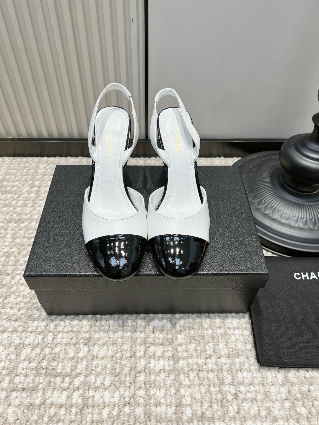NO:958645,G081 CHANEL white and black color-blocked round toe stiletto sandals 26ss with empty back. Refreshing black and white classic color matching | The king of all-match spring and summer commuting. The milky white matte cowhide shoe body is matched with a shiny black patent leather toe, and the retro style color matching is fully recognizable; the rounded toe is loose and accommodating to the toes, the stiletto heel elegantly elongates the leg line, the small red embellishment on the heel is exquisite and eye-catching, and the empty back strap is breathable and refreshing.  Suitable for shirt skirts, A-line dresses, and simple suits. Suitable for commuting to work, dating, afternoon tea, and light formal occasions. It is clean, refreshing and elegant!  Upper layer of cowhide, foot pads, sheepskin cushions, outsole, genuine leather outsole, size 35-41, high heels sandals, chanel, chanel, sandals, high heels, skirts, shirts, business suit, cowhide, sheepskin, Leather soles19860909G081 CHANEL 香奈儿白黑拼色圆头细跟后空凉鞋26ss 清爽黑白经典配色｜春夏通勤百搭王者 奶白哑光牛皮鞋身搭配亮黑漆皮鞋头,复古小香风拼色辨识度拉满；圆润鞋头宽松包容脚趾,细高跟优雅拉长腿部线条,鞋跟红色小点缀精巧吸睛,后空绊带透气清爽. 适配衬衫半裙、A字连衣裙、简约西装套装,通勤上班、约会下午茶、轻正式场合都合适,干净清爽又显贵气！ 鞋面头层牛皮 垫脚羊皮软垫 大底真皮大底 码数35-41,高跟鞋凉鞋,chanel,chanel,sandals,high heels,skirts,shirts,business suit,cowhide,sheepskin,Leather soles,Women's Shoes