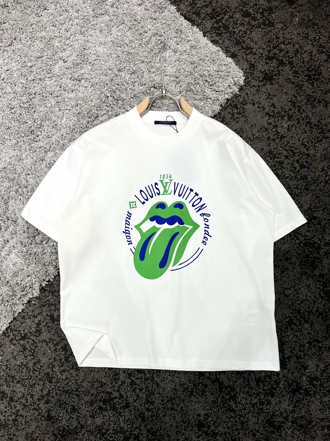 NO:125323,Louis Vuitton X Chrome Hearts long shoulders wide bust sleeves S7153.55924 M73556125 L7556.56326 XL77586527 Recommended size S/100-120M/ 120-150L/150-170XL/ 170-200 Co-branded printed logo short-sleeved T-shirt *Use 280g Xinjiang cotton ice-sensing Solona fabric  It has multiple characteristics such as cool ice skin, skin-friendly and breathable, quick-drying and antibacterial, moisture-absorbing and sweating. This fabric uses Xinjiang cotton as the main component to ensure the comfort and durability of the fabric. At the same time, through Solona technology, the fabric can bring a cool touch when worn in summer and effectively reduce the body temperature. In addition, the fabric also has good breathability and antibacterial properties, which can keep the skin dry and reduce bacterial growth. The moisture-absorbing and sweating function can quickly discharge sweat when exercising or sweating, keep the body dry and comfortable. If you like the high-end version, you can choose the first choice. The three-dimensional and stylish OS tailoring of the garment, the full flesh-covering feeling of *The printed with a thick version of the letters pressing process, the joint series, the three-dimensional and the design sense is full. *The highly recognizable piece comes with a fashionable BGM, which will play simplicity to the extreme and create a different high-end fashionable feeling.  Washing method is recommended to dry cleaning or wrap the back of the laundry bag, separate cold water, quick machine washing, natural drying model AMC2514, male and female models, white, black S-Xl,,louis vuitton,chrome hearts,T-shirt,tees,t-shirt,alexander wang19860909Louis Vuitton X Chrome Hearts 衣长肩宽胸围袖长 S7153.55924 M73556125 L7556.56326 XL77586527 推荐尺寸 S/100-120M/ 120-150L/150-170XL/ 170-200 联名印花标识短袖T恤 *采用280克新疆棉冰感索罗娜面料 具有凉感冰皮、亲肤透气、速干抗菌、吸湿排汗等多重特性.这种面料采用了新疆棉作为主要成分,保证了面料的舒适度和耐用性.同时,通过索罗娜科技处理,使得面料在夏季穿着时能带来冰凉的触感,有效降低体感温度.此外,该面料还具有良好的透气性和抗菌性能,能够保持皮肤干爽,减少细菌滋生.吸湿排汗功能则能在运动或出汗时迅速将汗水排出,保持身体干爽舒适.成衣普洗 喜欢高版本的可以首选 成衣立体有型OS剪裁 遮肉拉垮感满满 *大舌头品牌元素印花 厚版字母压胶工艺拼接,联名系列,立体感强 设计感拉满. *辨识度超高的一件,自带时髦BGM,将简约玩到极致,碰撞出不一样的高阶时髦感. 洗涤方式建议干洗或包裹洗衣袋反面单独冷水快速机洗自然晾干型号AMC2514 男女同款 白色 黑色 S-Xl,,louis vuitton,chrome hearts,T-shirt,tees，t-shirt,alexander wang,Men's clothing