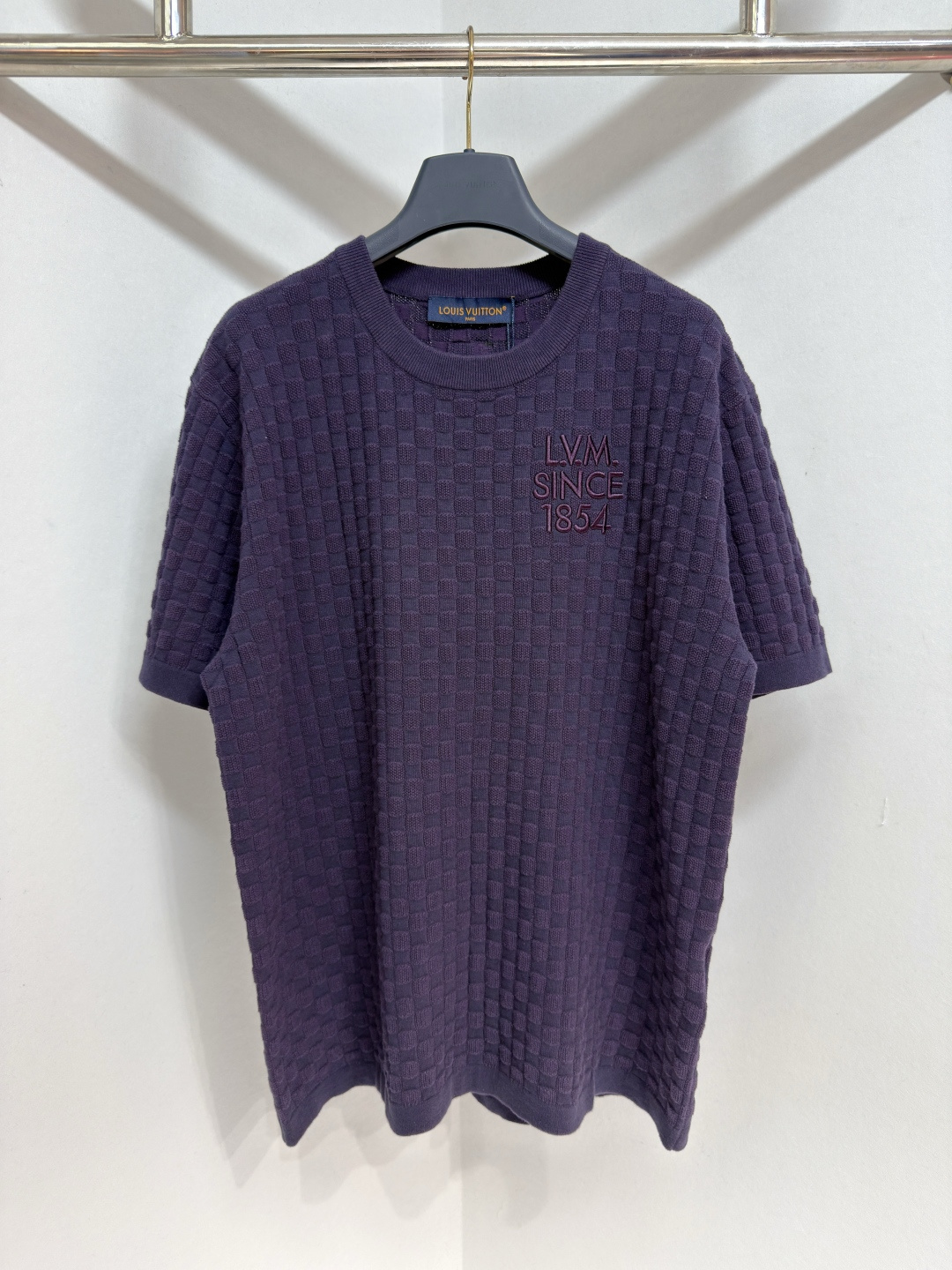NO:778021,1V 26ss 1854Damier jacquard short-sleeved crew neck shirt. This short-sleeved cotton crew neck shirt adopts this season's popular dark purple tone and is decorated with a richly textured Damier knitted pattern. The chest is embellished with the same color embroidered LV letter logo, and the back is decorated with a leather Marque L.Vuitton Déposée logo patch. The low-key design adds a restrained and sophisticated atmosphere to daily looks.  Size S-XL,Louis Vuitton-clothing,louis vuitton,louis vuitton,T-shirt,198609091V 26ss 1854Damier提花短袖圆领衫 这款短袖棉质圆领衫采用本季流行的深紫色调,饰以纹理丰富的 Damier 针织图案.胸前点缀着同色系刺绣 LV 字母标志,背面则饰有皮革 Marque L.Vuitton Déposée 徽标贴片.低调的设计为日常造型增添了一份内敛而精致的气息 尺码S-XL,路易威登-服装,louis vuitton,louis vuitton,T-shirt,,Women's clothing