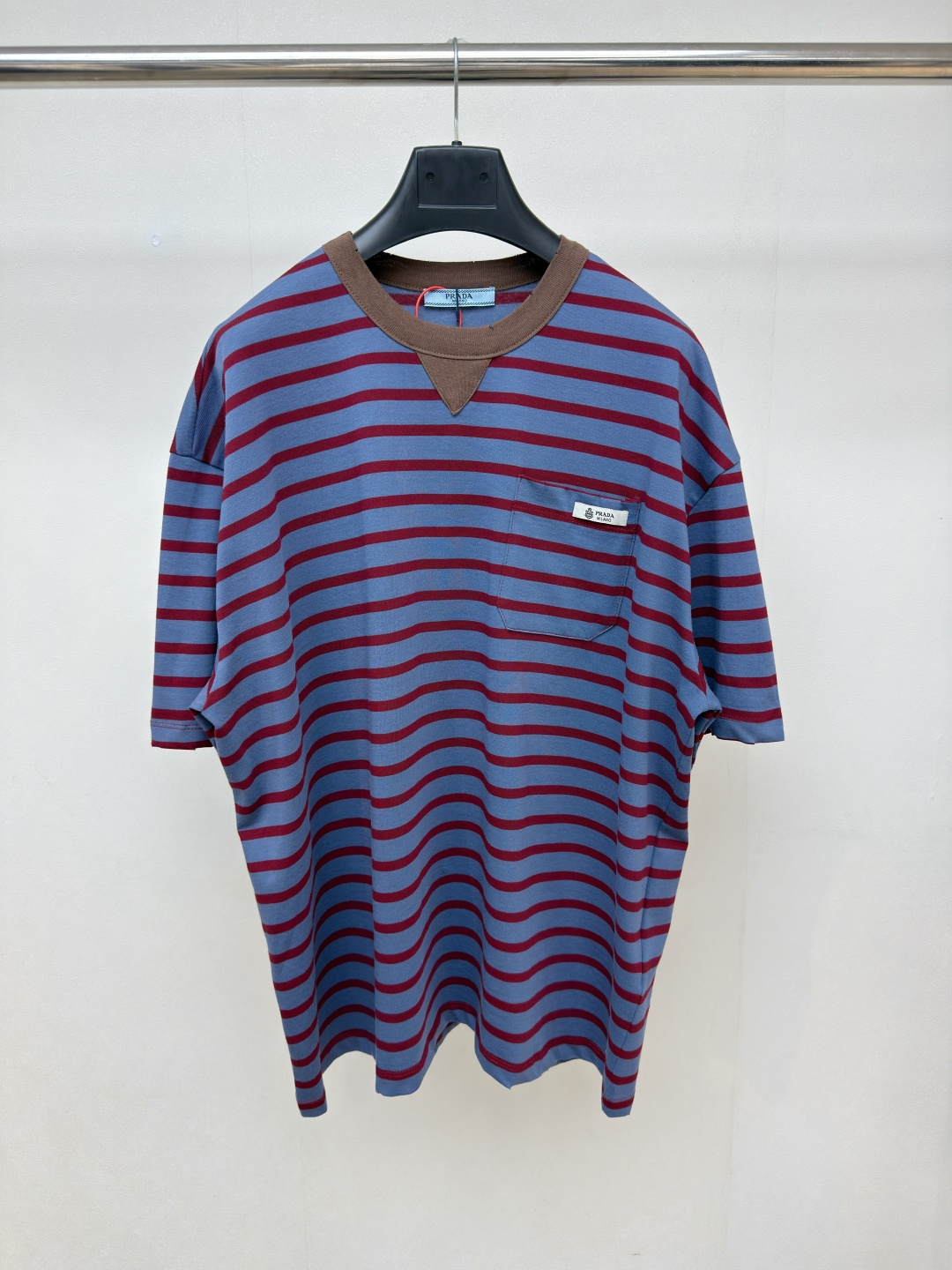 NO:783296,Prada striped pocket short sleeves, custom-dyed double-strand plain knitted fabric, delicate and soft, comfortable and close to the skin. The main body is based on blue and red stripes, which releases strong visual tension and has a nostalgic atmosphere. The brown splicing decoration of the inverted triangle is embedded under the collar, and the chest patch pocket logo label is the finishing touch. It is low-key but cannot be concealed. It tells the brand's ingenuity in the details. Every inch is a gentle deconstruction of order, giving the wearer a smart aura and elegant style.  Size XS - L,Prada-clothing,prada,prada,T-shirt,19860909Prada 条纹口袋短袖 定制色织双股平纹肌理针织料 细腻柔软 舒适贴肤 主体以蓝红相间的条纹为基调 释放出强烈的视觉张力 自带怀旧气息 倒三角的棕色拼接装饰镶嵌在领口之下 而胸前贴袋徽标标签如点睛之笔 低调却难掩精致 于细节处诉说品牌匠心 每一寸都是对秩序的温柔解构 赋予穿着者灵动的气场与优雅的格调 尺码 XS - L,普拉达-服装,prada,prada,T-shirt,,Women's clothing