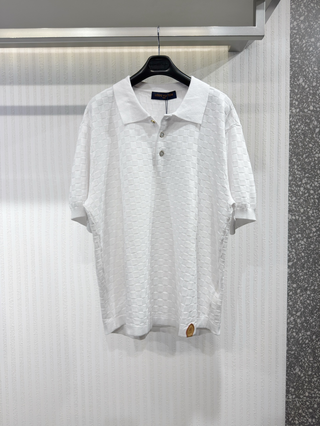 NO:779807,1V Knitted Silk Cotton Damier Pique Polo This short-sleeved polo is made from lustrous silk-cotton blend pique, which is lightweight and breathable. The Damier check pattern is applied throughout and is rendered in a richly textured jacquard knit for a refined style. LV stitching accents the buttons, and a VVN leather panel at the left hem pays homage to the brand's heritage in leather goods. This classic piece can be easily worn for formal or everyday looks.  Size S-XL,Louis Vuitton-clothing,louis vuitton,louis vuitton,T-shirt,198609091V 针织丝棉 Damier Pique Polo 衫 这款短袖 Polo 衫采用光泽感十足的丝棉混纺珠地布面料,轻盈透气.通体饰以 Damier 格纹图案,并以纹理丰富的提花针织工艺呈现,更添精致格调.LV 缝线点缀纽扣,左下摆的 VVN 皮革饰片则致敬品牌皮革制品的悠久传承.这款经典单品可轻松驾驭正式或日常造型 尺码S-XL,路易威登-服装,louis vuitton,louis vuitton,T-shirt,,Women's clothing