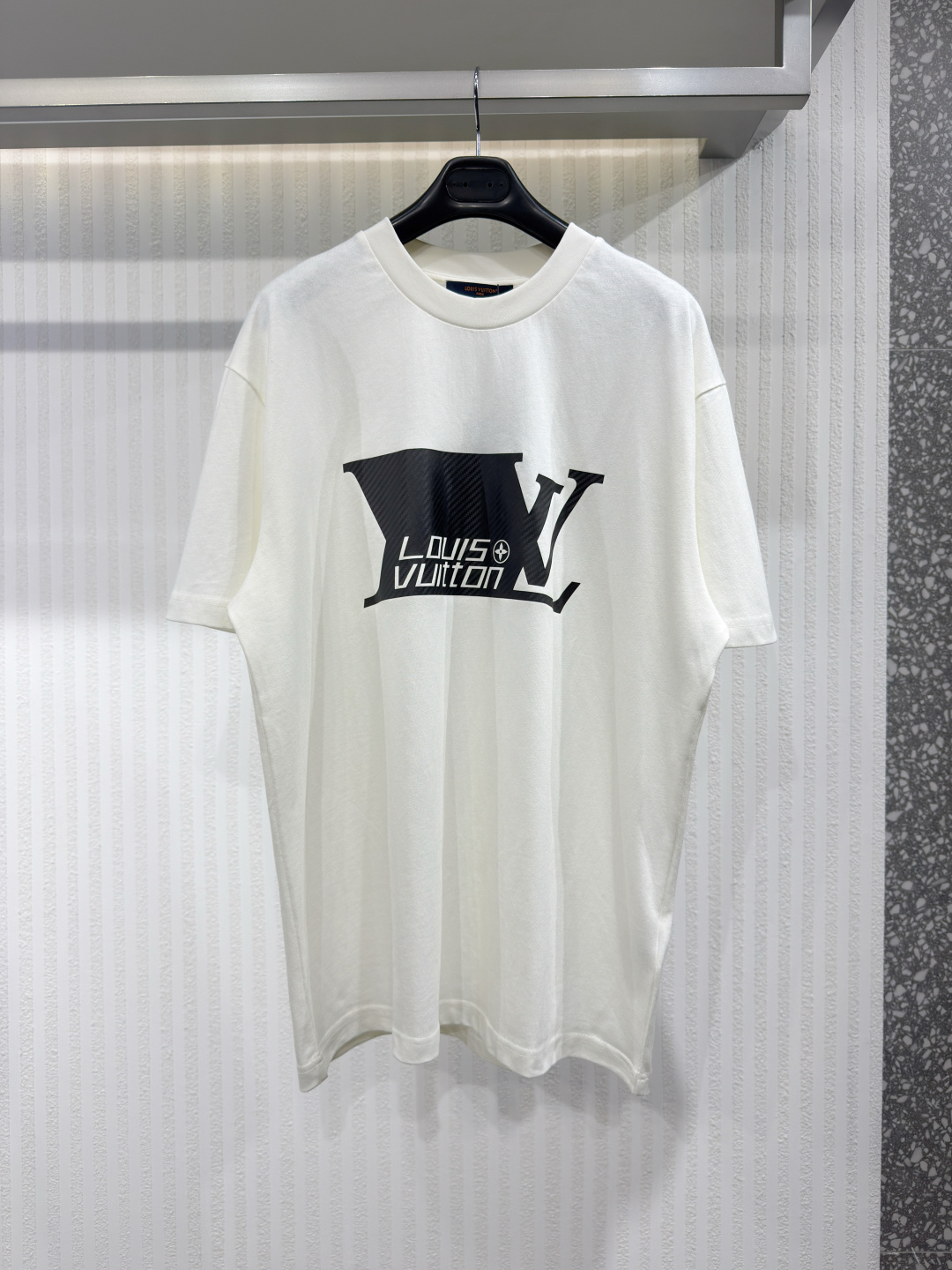 NO:779787,1V Spring/Summer 2026 short-sleeved monogram print cotton crew neck T-shirt white This classic white T-shirt is made of lightweight cotton sweater decorated with a graphic signature. A black LVSprinter pattern is printed on the front, with a sophisticated carbon fiber trompe l'oeil effect. On the back is the Vuitton signature and a monogrammed flower, made with the same craftsmanship. This sports piece is suitable for layering and creates a stylish contrast with the season's black wheels. Sizes XS-L, Louis Vuitton-clothing, louis  vuitton,louis vuitton,T-shirt,tees,t-shirt,198609091V 2026春夏款短袖字母印花纯棉圆领T恤白色 这件经典白色T恤轻薄棉质针织衫上装饰着图案签名.车头印有黑色LVSprinter图案,配有精致的碳纤维错视效果.背面则是威登签名和一朵字母组合花,采用同样的工艺制作.这件运动单品适合叠穿,与当季黑色轮型形成时尚对比.尺码XS-L,路易威登-服装,louis vuitton,louis vuitton,T-shirt,tees，t-shirt,,Women's clothing