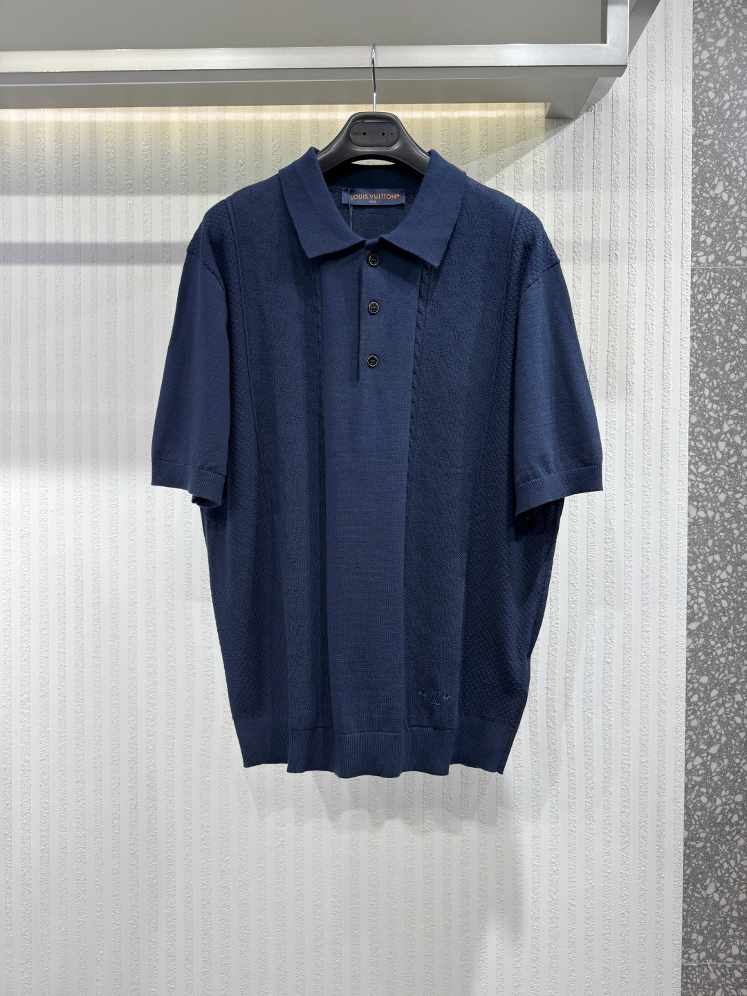 NO:817371,1V 26 Cotton and Silk Blend Open Knit Polo Shirt This dark blue short-sleeved polo shirt is knitted from fine cotton and silk blend yarn. It is decorated with a lightweight open knit pattern on the front and is embellished with decorative details such as understated Monogram and Damier logos. Tonal brand embroidery on the left hem and leather stitching on the back LV  Logo patch. This comfortable layering piece is soft and breathable for warm weather and adds a touch of preppy style to formal looks. Sizes S-XL, Louis Vuitton-Clothing, louis vuitton, louis vuitton, T-shirt,198609091V 26 棉丝混纺镂空针织Polo衫 这款深蓝色短袖 Polo 衫采用精细棉丝混纺纱线针织而成,正面饰以轻盈的镂空针织图案,并点缀有低调的 Monogram 和 Damier 标志等装饰细节.左下摆饰有同色系品牌刺绣,背面则缝有皮革 LV 标志贴片.这款舒适的叠穿单品柔软透气,适合温暖的天气穿着,为正式造型增添一抹学院风情.尺码S-XL,路易威登-服装,louis vuitton,louis vuitton,T-shirt,,Women's clothing