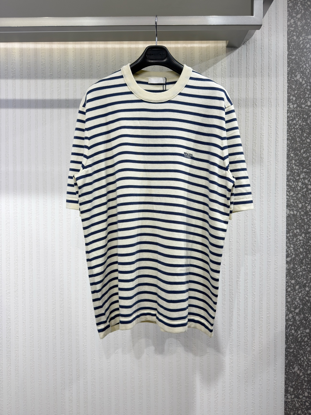 NO:826473,PRAD 26 Striped Short Sleeve Cotton Woolen T-Shirt This Prada sweater has simple and smooth lines, and the short-sleeved cotton round neck stripe pattern gives a refined and casual feel. The embroidered brand logo on the chest is a low-key highlight of the brand, and the slim fit makes it look neat and capable whether paired with formal or casual items. As a masterpiece among men's sweaters, it adds precise lines and versatile style to the modern men's wardrobe.  Size 46-52, Prada-clothing, prada, prada, sweaters, T-shirt, tees, t-shirt,19860909PRAD 26条纹短袖棉质毛织T恤这款 Prada 毛衣线条简洁流畅,短袖棉质圆领条纹图案尽显精致休闲之感.胸前的刺绣品牌标识低调彰显品牌特色,而修身的版型则使其无论搭配正装还是休闲单品,都能展现利落干练的气质.作为男士针织衫中的一件佳作,它为现代男士衣橱增添了精准的线条感和百搭的风格 尺码46-52,普拉达-服装,prada,prada,sweaters,T-shirt,tees，t-shirt,,Women's clothing