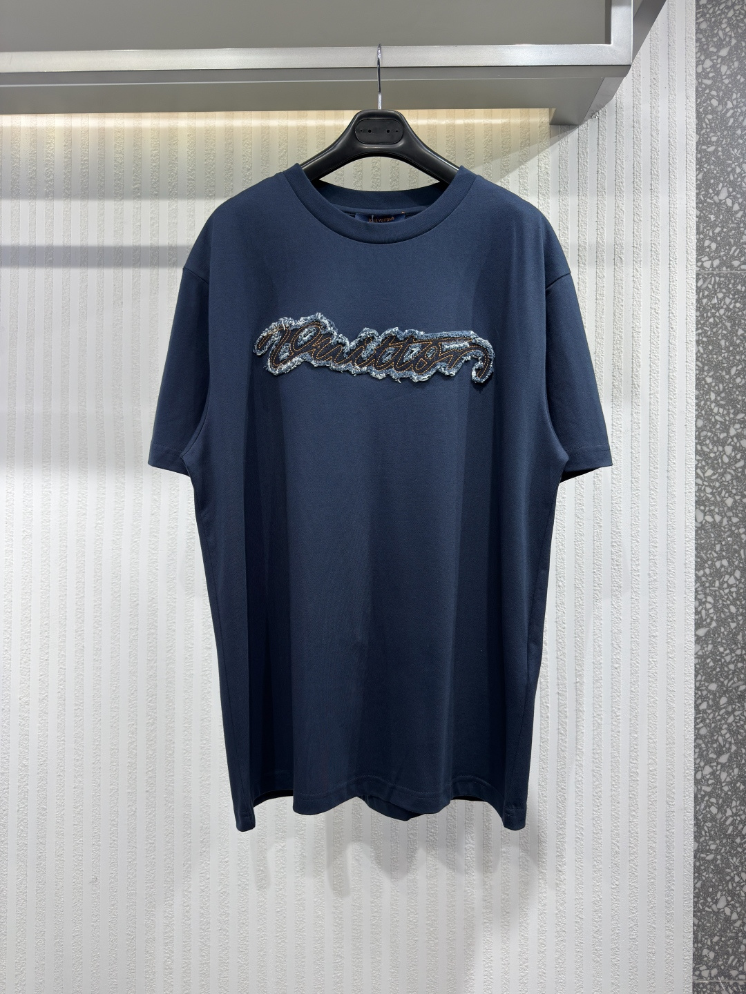 NO:826487,1V 2026 Autumn Denim Signature T-Shirt This classic dark blue T-shirt is decorated with Louis Vuitton's iconic cursive denim patch on the chest, and is presented with distressed texture embroidery technology, adding a unique charm. The back is embellished with 'Marque L.Vuitton  Déposée' woven label, low-key and refined. This versatile item easily enhances the style of casual summer looks. Sizes XS-L, Louis Vuitton-clothing, louis vuitton, tees, t-shirt,198609091V 2026年秋季牛仔签名T恤 这款经典的深蓝色T恤胸前饰有路易威登 (Vuitton) 标志性的草书牛仔布贴片,并以做旧质感的刺绣工艺呈现,更添独特韵味.背面则点缀着“Marque L.Vuitton Déposée”织唛,低调而精致.这款百搭单品轻松提升休闲夏日造型的格调.尺码XS-L,路易威登-服装,louis vuitton,tees，t-shirt,,Women's clothing