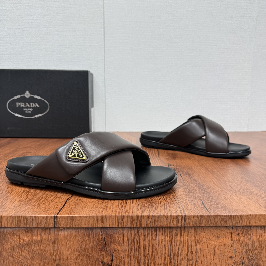 NO:353663,Prada/Prada New men's leather cross slippers Velcro opening and closing can finely adjust the size of calfskin light luxury slippers Thicker soft calfskin wrapped upper, Fat Ding soft glue lazy style, soft and comfortable, excellent foot feeling, genuine leather bottom, cross style, paired with a Velcro opening and closing buckle, easy to adjust the moderate size, and perfectly fit the wearing experience. Enamel gold triangle logo, highlighting the brand's classic features, lightweight rubber thin bottom, extremely comfortable on the feet!  Full package!  Size 39-40-41-42-43-44-45 Leather Shoe Size Article No. 2X7132 Brown,,prada,prada,slippers,cowhide19860909批 Prada/普拉达 新款男士皮革交叉拖鞋 魔术贴开合可微调大小小牛皮轻奢拖鞋 较厚软小牛皮包裹鞋面,胖丁软胶懒庸风格,柔软舒适,脚感极好,真皮底层 ,交叉风格,搭配一条魔术贴开合扣带,轻松调节适度大小,更能完美契合穿着体验感,涂珐琅金色三角形徽标,彰显品牌经典特色,轻质橡胶薄底,上脚舒适度极高！全套包装！ 尺码39-40-41-42-43-44-45 皮鞋尺码 货号2X7132 棕色,,prada,prada,slippers,cowhide,Men's shoes