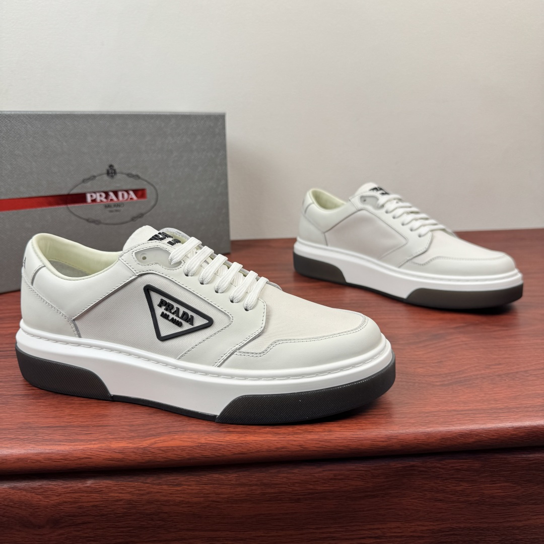 NO:779939,Batch Prada/Prada's first new men's thick-soled leather patchwork sneakers, lightweight casual thick-soled sneakers!  This sneaker adopts sporty style and neat classic lines, with a thick sole design and is highlighted by contemporary minimalist details. The casual and versatile style is embellished with embossed triangle logo badges, highlighting a unique classic style. Selected high-quality waxed calfskin leather spliced with Prada classic technical mesh material. Contrasting colors highlight the features. The leather texture is uniform and shiny. The pores are clearly visible. Excellent toughness. Resistant to bending and creases. Soft and comfortable. Calf leather lining. Thickened latex insole.  Genuine leather bottom layer, great touch on the foot, classic rubber label letter logo tongue details, contrasting light rubber outsole, bottom transparent rubber soft sole, shock-absorbing grip, wear-resistant and non-slip, classic sneakers that are easy to wear and versatile, complete package!  Size 39-40-41-42-43-44 leather shoe size (can be customized individually 38.45.46 non-returnable) Item number 2EG453 leather cloth white, prada, prada, sneakers, cowhide19860909批 Prada/普拉达 首发新款男士厚底皮革拼布运动鞋 轻质休闲厚底板鞋！ 这款运动鞋鞋采用运动风格与利落的经典线条,搭配厚底设计 ,以当代极简细节为亮点.休闲百搭风格点缀压花三角标徽章,彰显别具一格的经典格调. 甄选优质打蜡小牛皮皮革拼接Prada经典科技网布材质 撞色搭配凸显特色 皮料质感均匀 光泽透亮 毛孔清晰可见 韧性极好 耐弯曲折痕 柔软舒适 内里小牛皮 加厚乳胶鞋垫 真皮底层 上脚触感极好 经典胶标字母logo鞋舌细节 撞色轻质橡胶大底 底层透明橡胶软底 减震抓地 耐磨防滑 经典板鞋上脚轻松百搭 全套包装！ 尺码39-40-41-42-43-44皮鞋尺码（可单独定制38.45.46不退换） 货号2EG453皮布 白色,,prada,prada,sneakers,cowhide,Men's shoes