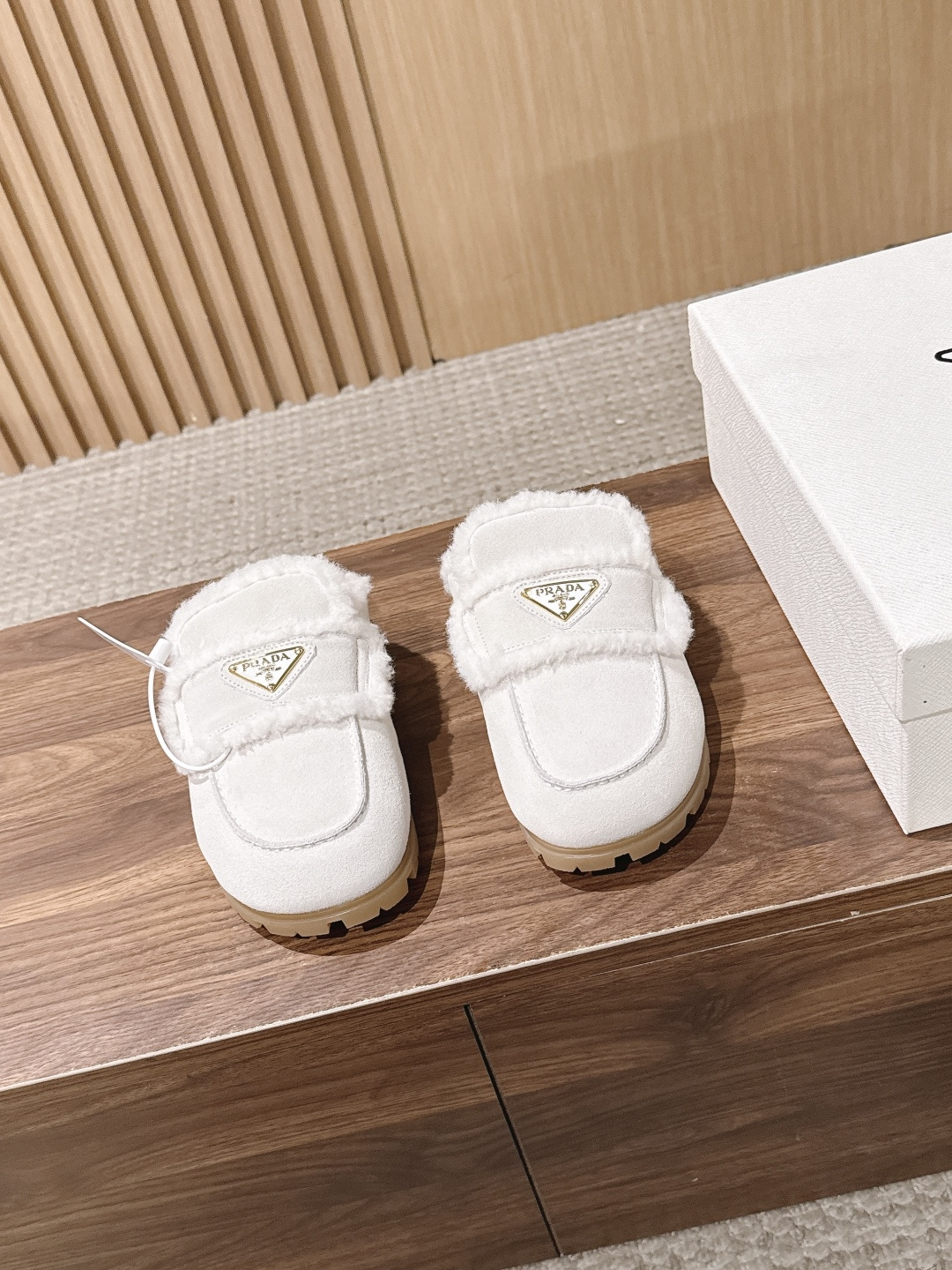 PRADA 普拉达秋冬三角扣复古包头半拖毛拖 这双毛拖无疑是先锋美学与慵懒格调的惊艳融合。标志性的三角扣以利落线条与精致