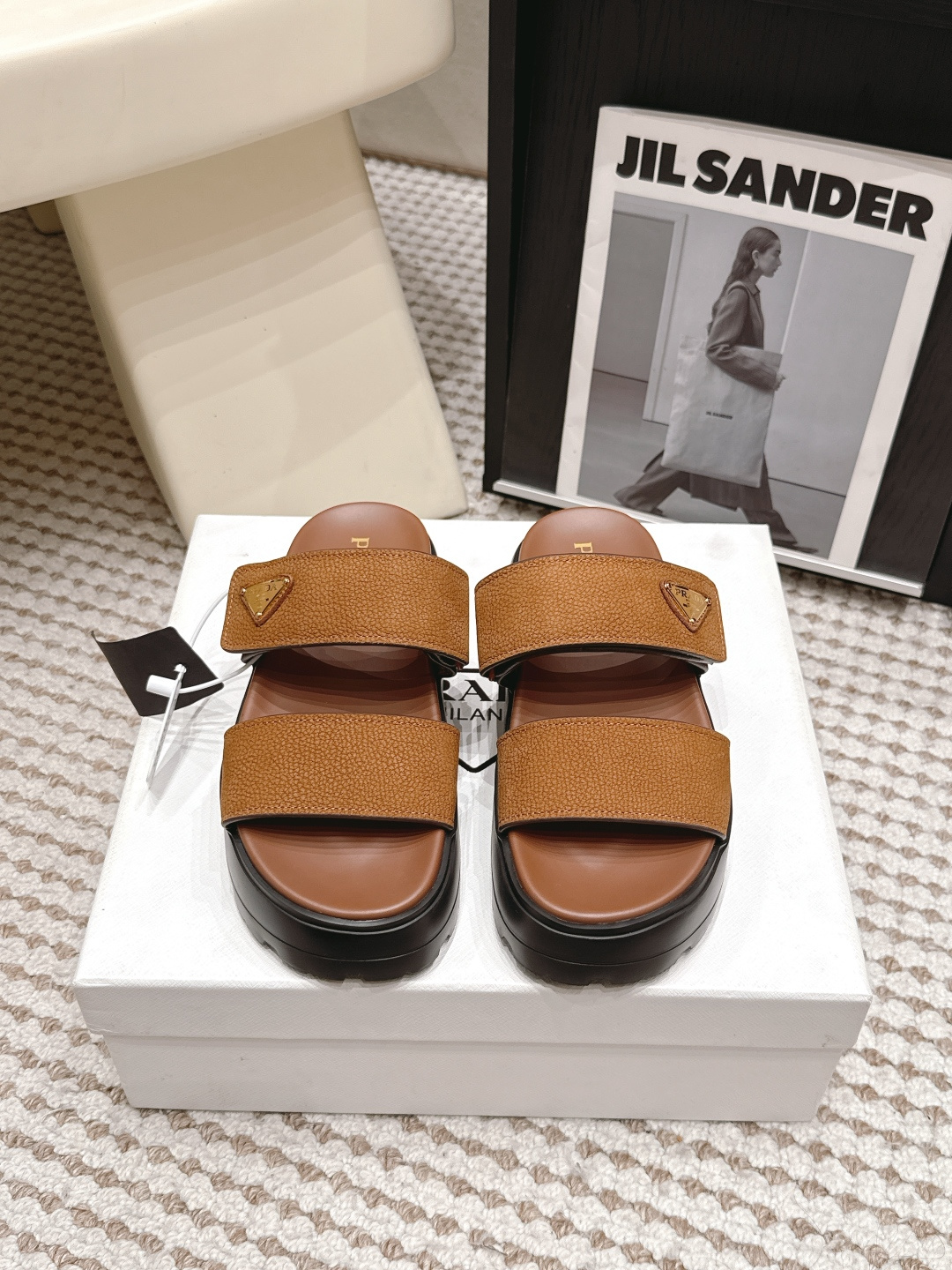 NO:814582,Purchasing agent PRAD*·26s spring and summer new style small thick bottom double one word sandals with metal buckle  The aura of this pair of sandals is like that of a female curator who quietly took off her high heels and put on these sandals at a gallery opening reception - the legs of her black suit trousers just covered the first belt on the shoe, leaving only the small metal buckle on the second belt exposed. The outline of the entire pair of shoes is still very slim  Jane's double-strap structure has two straps, one across the base of the toes, one across the highest point of the instep, and the rest are deleted. The bone lines of the toes, arches, and ankles are returned to the wearer without any obstruction. This magnanimity is not deliberate nudity, but a calmness that is too lazy to cover up.  Material: cow suede, sheep lining, outsole, rubber outsole, shoe size 35-39/40, 41 customization, non-returnable, slippers, prada, high heels, slippers, business suit19860909代购级 PRAD*·26s 春夏新款 小厚底双一字带金属扣凉拖 这双凉拖的气质,像一位在画廊开幕酒会上悄悄脱掉高跟鞋、换上这双凉拖的女策展人——她的黑色西装裤脚刚好盖过鞋面的第一条皮带,只露出第二条皮带上的那一枚小小的金属扣.整双鞋的轮廓依旧是极简的双一字带结构两条皮带,一条横过脚趾根部,一条横过脚背最高处,其余全部删去.脚趾、足弓、脚踝的骨骼线条被毫无遮挡地交还给穿着者自己,这种坦荡不是刻意的裸露,而是一种懒得遮掩的从容. 材质牛反绒 内里羊里 大底橡胶大底 鞋码35-39/40 41定制不退换,拖鞋,prada,high heels,slippers,business suit,Women's Shoes