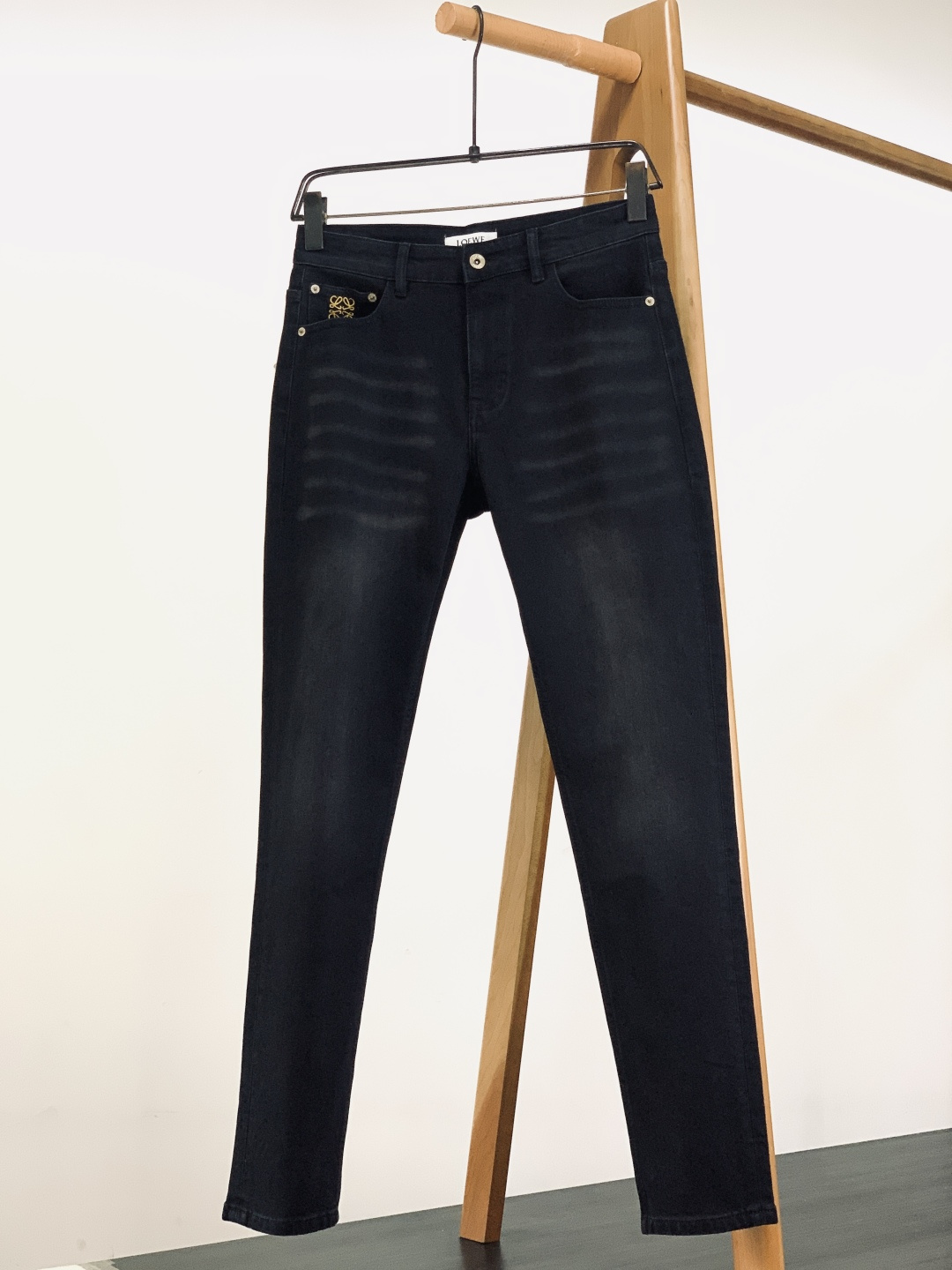 NO:595076,Loewe Paula’s Ibiza limited-edition jeans are made of high-density twill denim, which has been specially washed to present a natural distressed texture. It has the stiff texture of denim, but also has slightly elastic properties, which fit the body shape without restricting movement; the neat tailoring weakens the heavy feeling of denim, and the length is just right to expose the ankle. It is suitable for sneakers, leather shoes and other shoe types, and can easily create a high-end dressing formula of 'traditional and simple'.  The brass buttons at the placket are engraved with the brand's embossed words and matched with metal rivets of the same series, revealing a low-key luxury in the retro texture; the leather label on the inside of the waistband is embossed with the brand's logo, and the stitching is neat and delicate, which is the iconic craftsmanship of luxury goods; above the front pocket is the classic 'Anagram embroidery', and the golden embroidery thread is particularly eye-catching on the black cow background, which is a highly recognizable symbol of the brand; the back pocket is the soul of this joint brand - Paula's  Ibiza's iconic graffiti font embroidery, yellow + blue contrasting embroidery threads bring a retro pop art feel, injecting a free and relaxed island atmosphere into minimalist jeans. The seams of the trousers are made of high-density stitching of the same color, and the stitching is even and neat, and will not be easily deformed after long-term wear; the trousers are designed with simple curling, which not only retains the casualness of the denim, but also adds a sense of layering through the exposed inner fabric pattern; the pocket edges are reinforced to take into account both beauty and practicality.  This pair of jeans can become the finishing touch of the look with its characteristics of 'black background color + artistic logo'. ……………………………………………… Size29-38,,loewe,loewe,jeans,alexander wang19860909Loewe 罗意威 Paula’s Ibiza 限定款牛仔裤 选用高密度斜纹牛仔布,经特殊水洗工艺呈现自然做旧纹理,既有牛仔的挺括质感,又带微弹属性,贴合身形却不束缚活动； 利落的剪裁弱化了牛仔的厚重感,长度恰好露出脚踝,适配球鞋、皮鞋等多种鞋型,轻松打造「上繁下简」的高级穿搭公式. 门襟处的黄铜纽扣刻有品牌浮雕字样,搭配同系列金属铆钉,复古质感中透出低调奢华；腰头内侧的皮质标牌压印品牌Logo,缝线工整细腻,是奢品的标志性工艺；前袋上方是经典的「Anagram 回纹刺绣」,金色绣线在黑牛底色上格外醒目,是品牌的高辨识度符号；后袋则是本次联名的灵魂——Paula‘s Ibiza标志性涂鸦字体刺绣,黄+蓝撞色绣线自带复古波普艺术感,为极简牛仔注入自由松弛的海岛氛围. 裤身接缝处采用同色系高密度车线,针脚均匀利落,久穿不易变形；裤脚采用简约卷边设计,既保留了牛仔的随性,又能通过露出的内侧布纹增加层次感；口袋边缘的加固处理,兼顾美观与实用性. 这条牛仔裤能凭借其「黑底色+艺术感Logo」的特质,成为造型的点睛之笔. …………………………………………………… Size29-38,,loewe,loewe,jeans,alexander wang,Men's clothing