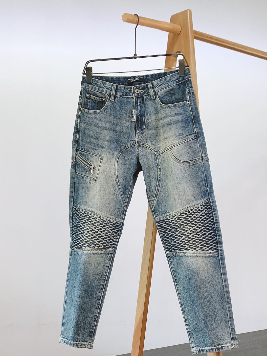 NO:595673,Philipp plein 2025FW early autumn new product Distressed motorcycle style jeans, a collision of rebellious aesthetics and heavy industrial details. Made of high-weight washed denim, the hand-made old and whitened process creates a natural blue and white gradient effect, which not only has the relaxation of retro 'cow raising', but also retains the stiffness of the denim fabric. At the same time, the distressing process weakens the stiffness and makes the upper body more comfortable.  Diamond quilted panels are added to the trouser legs to replicate the classic elements of motorcycle jackets, adding three-dimensionality while enhancing the street coolness; Zippered pockets on the front (full of metal zipper texture) + classic diagonal pockets, double patch pockets on the back, taking into account both decoration and practicality; Skull and crossbones embroidery on the back pocket (matched with the brand logo) + Leather nameplate on the back waist (embossed with the brand logo and skull elements)  Metal buttons, contrasting topstitching, and details enhance the texture of work clothes, and the overall style is tough yet refined. ……………………………………………… Size28-38,,PHILIPP PLEIN,jeans,jackets & coats,alexander wang19860909Philipp plein 菲利普.普兰茵 2025FW早秋新品 做旧机车风牛仔裤,叛逆美学与重工细节的碰撞. 采用高克重水洗牛仔布,通过手工做旧磨白工艺打造自然的蓝白渐变效果,既有复古“养牛”的松弛感,又保留了牛仔面料的挺括度,同时做旧处理弱化了硬挺感,上身更舒适. 裤腿处加入菱格绗缝拼接块,复刻机车夹克的经典元素,增加立体感的同时强化街头酷感； 前侧设拉链暗袋（金属拉链质感拉满）+ 经典斜插袋,后侧双贴袋,兼顾装饰性与实用性； 后袋处的骷髅交叉骨刺绣（搭配品牌标识）+ 后腰皮质铭牌（压印品牌Logo与骷髅元素） 金属纽扣、撞色明线走线,细节处强化工装质感,整体风格硬朗又不失精致. …………………………………………………… Size28-38,,PHILIPP PLEIN,jeans,jackets & coats,alexander wang,Men's clothing