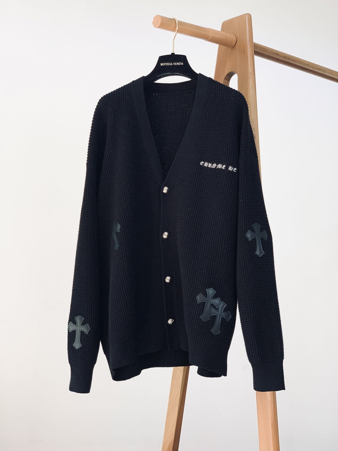 NO:595674,Chrome Hearts 2025FW new autumn and winter product Gothic knitted cardigan, weaving dark aesthetics into softness. The waffle knitting is soft and skin-friendly, and the black/light gray two-tone color is the 'versatile base color' for autumn and winter. The off-shoulder version is wrapped in casual relaxation, and the slit details at the back add a bit of laziness;  The arms are laminated with leather cross patches, and the neatly stitched Gothic silhouette is the brand DNA that can be recognized at a glance; the embroidered wording on the neckline + metal cross buttons weld 'dark sophistication' into every detail; worn alone is a cool literary style, with a white T-shirt underneath for a street trend, and when layered with a suit jacket, it can instantly become sophisticated and cool. A cardigan that combines 'gentleness' and 'rebellion', plays the tone of the autumn and winter wardrobe. ……………………………………………………  SizeS-XXL,,chrome hearts,chrome hearts,jackets & coats,business suit,alexander wang19860909Chrome Hearts 克罗心 2025FW秋冬新品 哥特式针织开衫,把暗黑美学织进软糯里. 华夫格针织软糯贴肤,黑/浅灰双色都是秋冬“百搭底色”,落肩版型裹出随性松弛,后摆开衩细节又添了几分慵懒； 手臂叠贴皮质十字架贴布,车线利落的哥特轮廓,是一眼就能认出的品牌DNA；领口绣字+金属十字纽扣,把“暗黑精致”焊在每处细节； 单穿是清冷文艺风,内搭白T露边是街头潮感,叠穿西装外套又能秒变轻熟酷盖. 一件把“温柔”和“叛逆”揉碎的开衫,秋冬衣柜的腔调担当. …………………………………………………… SizeS-XXL,,chrome hearts,chrome hearts,jackets & coats,business suit,alexander wang,Men's clothing