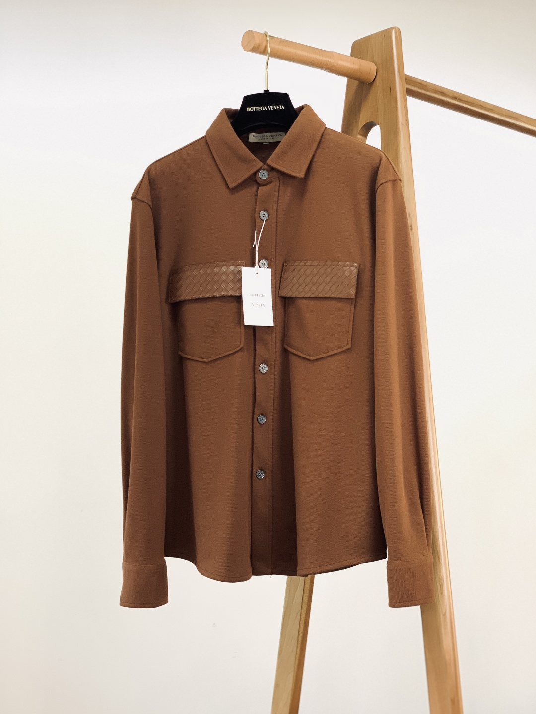 NO:595704,Bottega Veneta's 2025FW new autumn and winter products are the perfect fusion of low-key luxury and textured details~ The classic shirt style + workwear-style patch pockets bring a relaxed sense of luxury; the pockets are spliced with BV's iconic woven leather, with a delicate texture and recognition, and the woven triangle logo on the back is a low-key brand reminder.  The knitted fabric is soft and skin-friendly, taking into account comfort and stiffness; the double-button design of the cuffs can be adjusted for tightness, and the neckline and placket are neatly routed, and every detail is exquisite. Minimalist white, textured brown, and calm black are all non-distinguishing high-end colors, which can be used for daily commuting and casual dating. A shirt that can wear 'low-key luxury' on the body, easy to hold and effortless sophistication ~ ……………………………………………………  Size48-56,,bottega veneta,bottega veneta,bottega veneta,shirts,alexander wang19860909Bottega Veneta 葆蝶家 2025FW秋冬新品 低调奢华与质感细节的完美融合~ 经典衬衫版型+工装风贴袋,自带松弛的高级感；口袋处拼接BV标志性的编织皮质,纹理细腻又有辨识度,后背的编织三角标更是低调的品牌小心机. 针织面料柔软亲肤,兼顾舒适与挺括感；袖口的双纽扣设计可调节松紧,领口、门襟的走线工整利落,每一处都透着精致. 极简白、质感棕、沉稳黑,都是不挑人的高级色调,日常通勤、休闲约会都能搭出质感. 一件能把“低调奢华”穿在身上的衬衫,轻松拿捏不费力的精致感~ …………………………………………………… Size48-56,,bottega veneta,bottega veneta,bottega veneta,shirts,alexander wang,Men's clothing