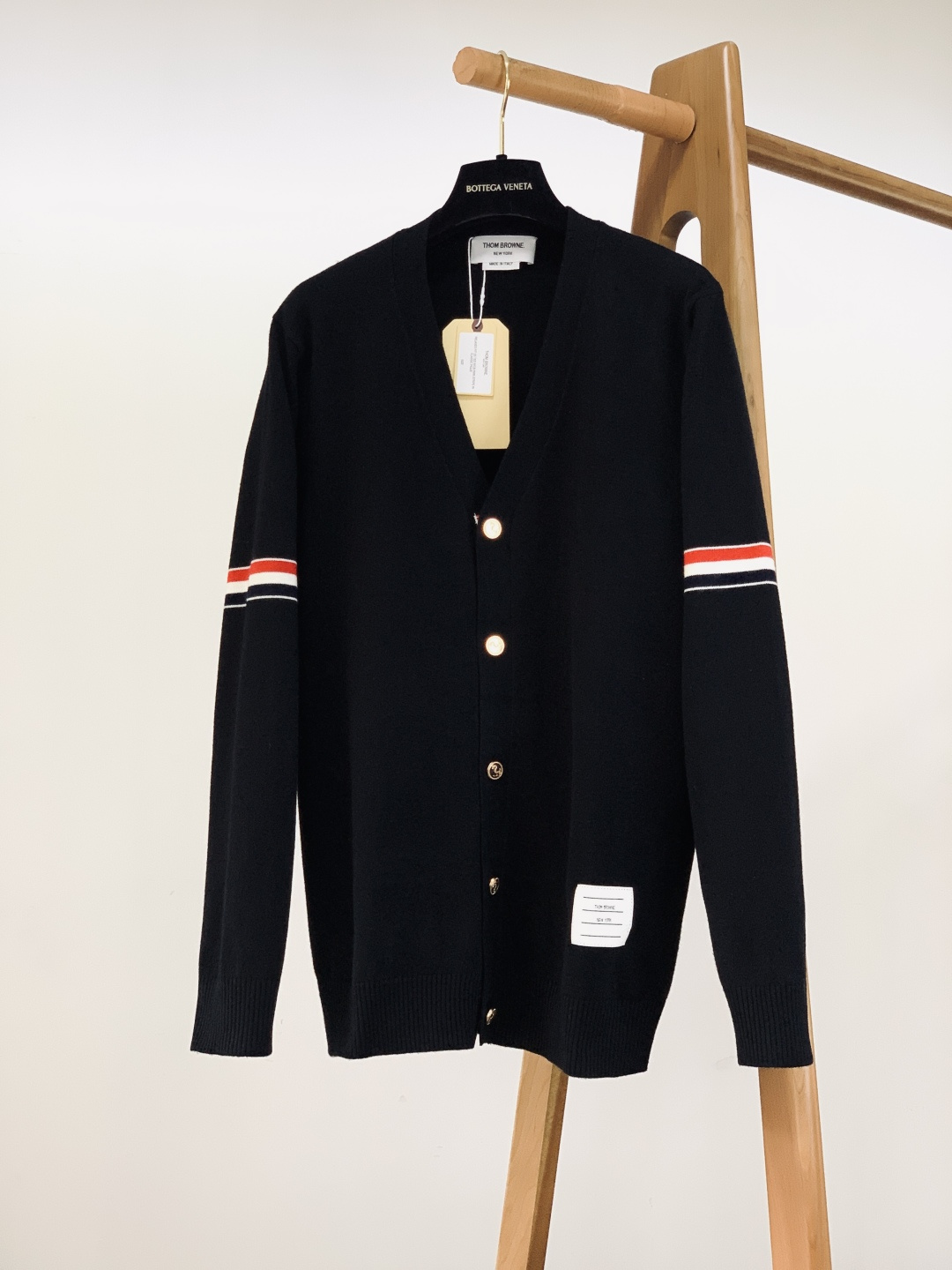 NO:599634,Thom Browne 2025FW new autumn and winter product casual knitted cardigan, the 'top college style' of American luxury brands. The cuffs + red, white and blue striped webbing on the back are the soul elements of TB's instantly recognizable logo, with its own 'effortless luxury brand aura'. Metal anchor buttons + chest brand label, every decoration hides the exquisiteness of American retro, and the Italian knitted fabric is soft and crisp, close to the skin, pressure-free and anti-wrinkle.  The V-neck cardigan style is 'elite college style' when paired with a shirt. It can be worn with a T-shirt to create a lazy and relaxed feeling. The three colors are black/navy blue/light gray, suitable for all scenes. The knitted material is just right in thickness, suitable for spring and autumn to be worn alone or layered in autumn and winter. It is a high-end basic model that 'lives up the whole wardrobe in one piece.' Wear the retro accents of American luxury brands into every moment of your daily life. ……………………………………………… SizeM-XXL,,thom  browne,shirts,tees,t-shirt,alexander wang19860909Thom Browne 汤姆·布朗 2025FW秋冬新品 休闲针织开衫,美式奢牌的“学院风顶流”. 袖口+后背的红白蓝条纹织带,是TB一眼识标的灵魂元素,自带“不费力的奢牌气场”. 金属锚形纽扣+胸前品牌贴标,每处装饰都藏着美式复古的精致,意产针织面料软而挺括,贴肤无压还抗皱 V领开衫版型,搭衬衫是“精英学院风”,配T恤又能穿出慵懒松弛感,黑/藏青/浅灰三色,适配全场景穿搭 厚度刚好的针织材质,春秋单穿、秋冬叠穿都合适,是“一件盘活整个衣橱”的高阶基础款. 把美式奢牌的复古腔调,穿进日常每一刻. …………………………………………………… SizeM-XXL,,thom browne,shirts,tees，t-shirt,alexander wang,Men's clothing