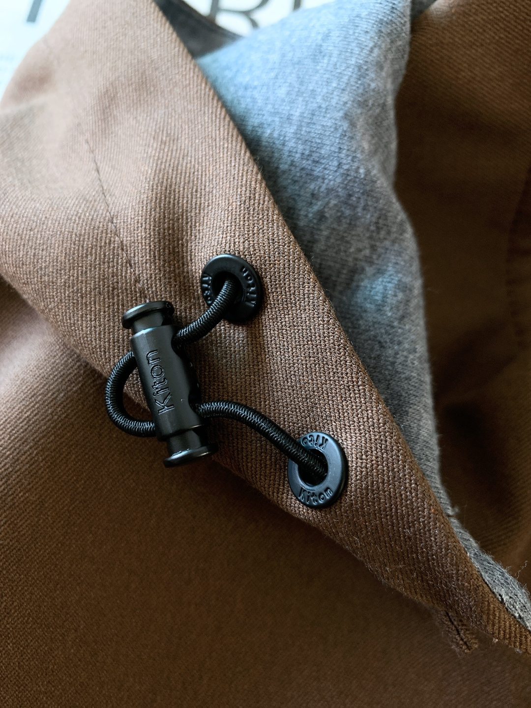 Kiton 奇顿 2025FW秋冬新品 可拆卸连帽外套。连帽内侧采用灰色针织面料，与外层棕调肌理面料形成