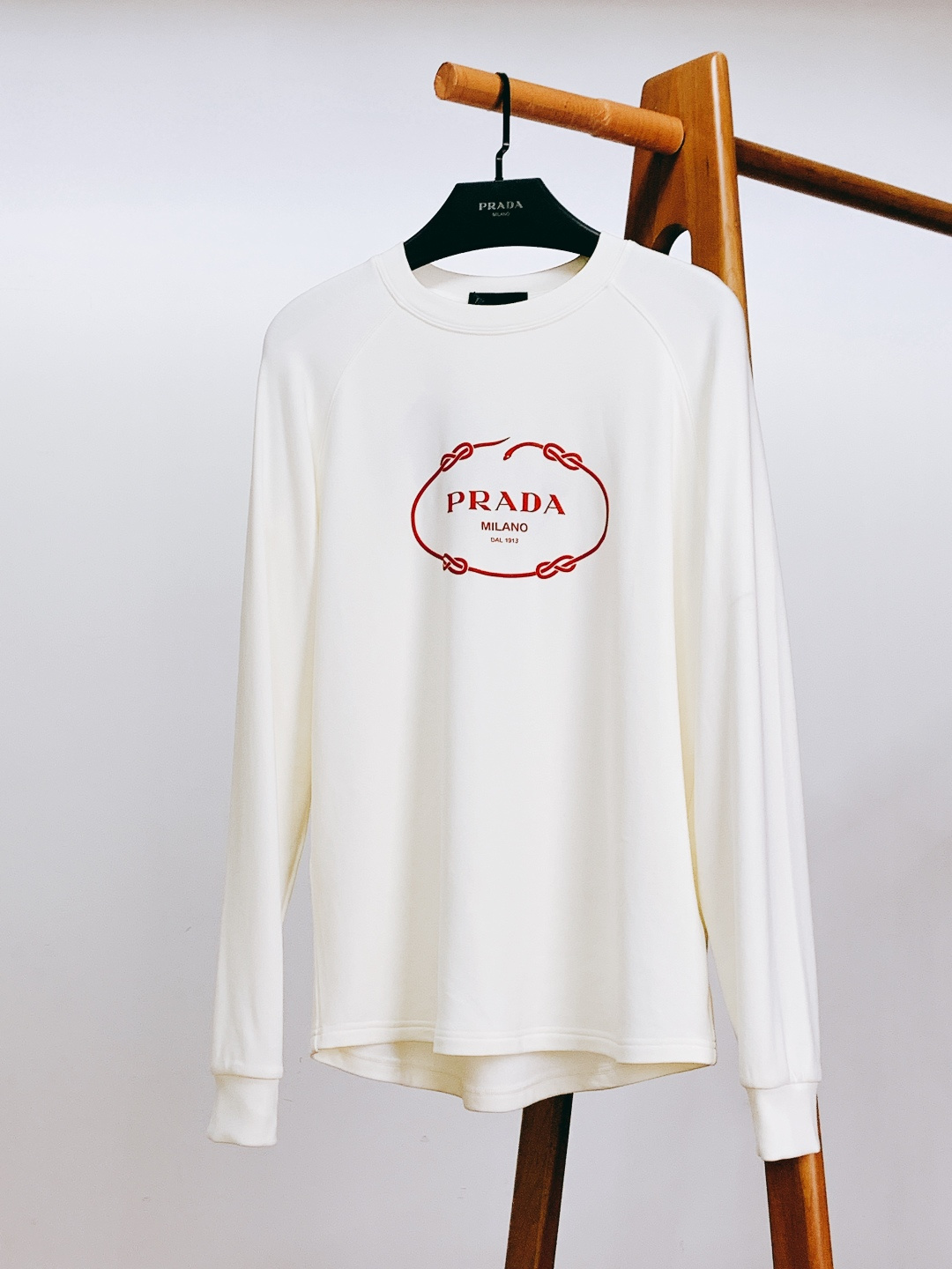 Prada 普拉达 2025FW秋冬新品 绳结标识打底卫衣。胸前品牌字母标识字样+绳结环绕标识，红标撞色